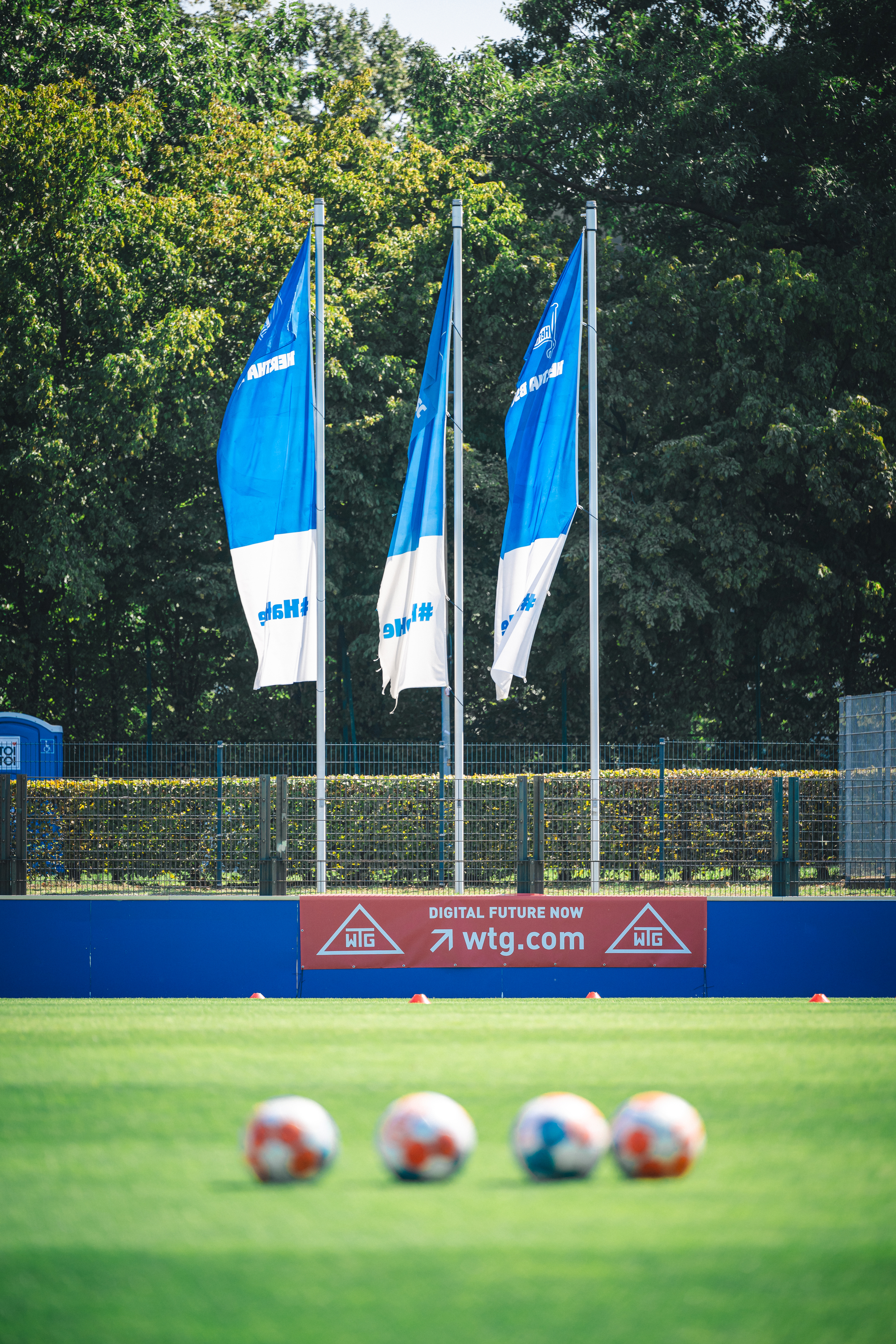 Trainingsbälle und wehende Fahnen im Olympiapark.