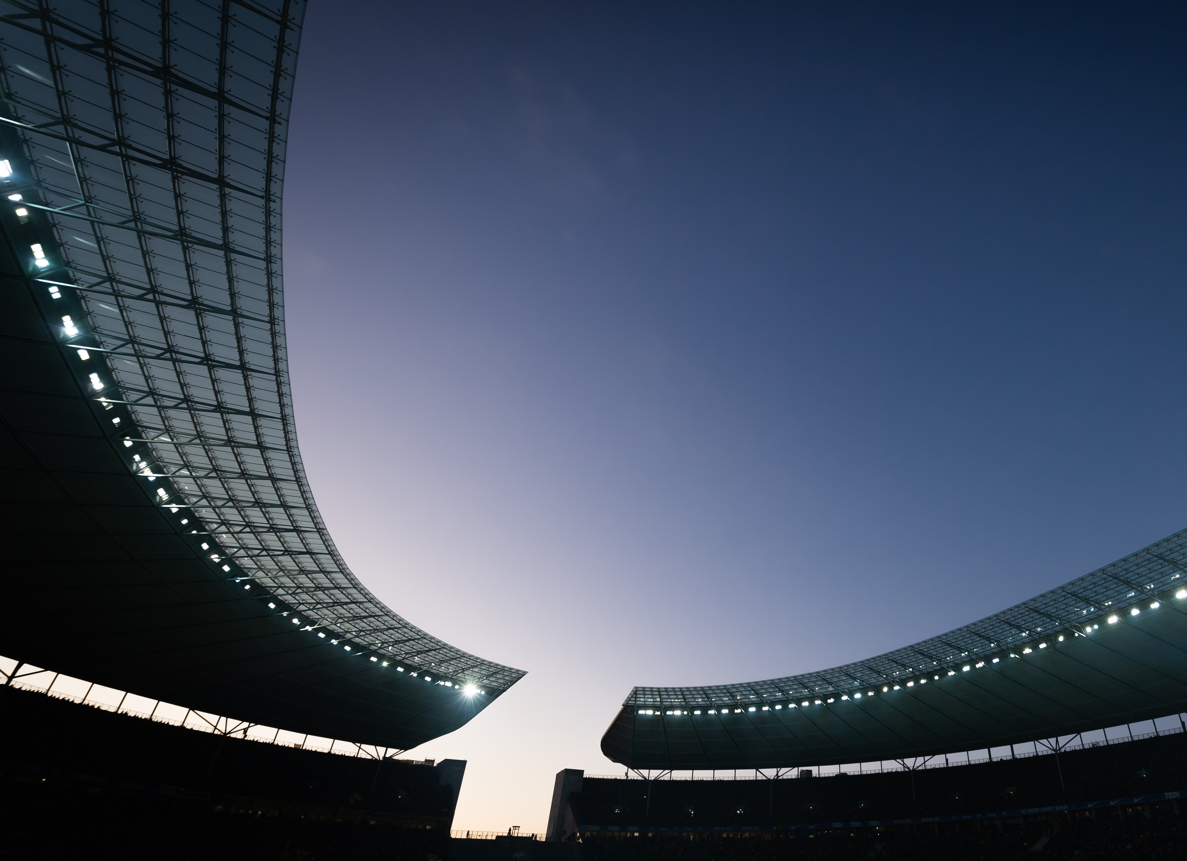 Angeschaltetes Flutlicht an einem Abend im Olympiastadion.