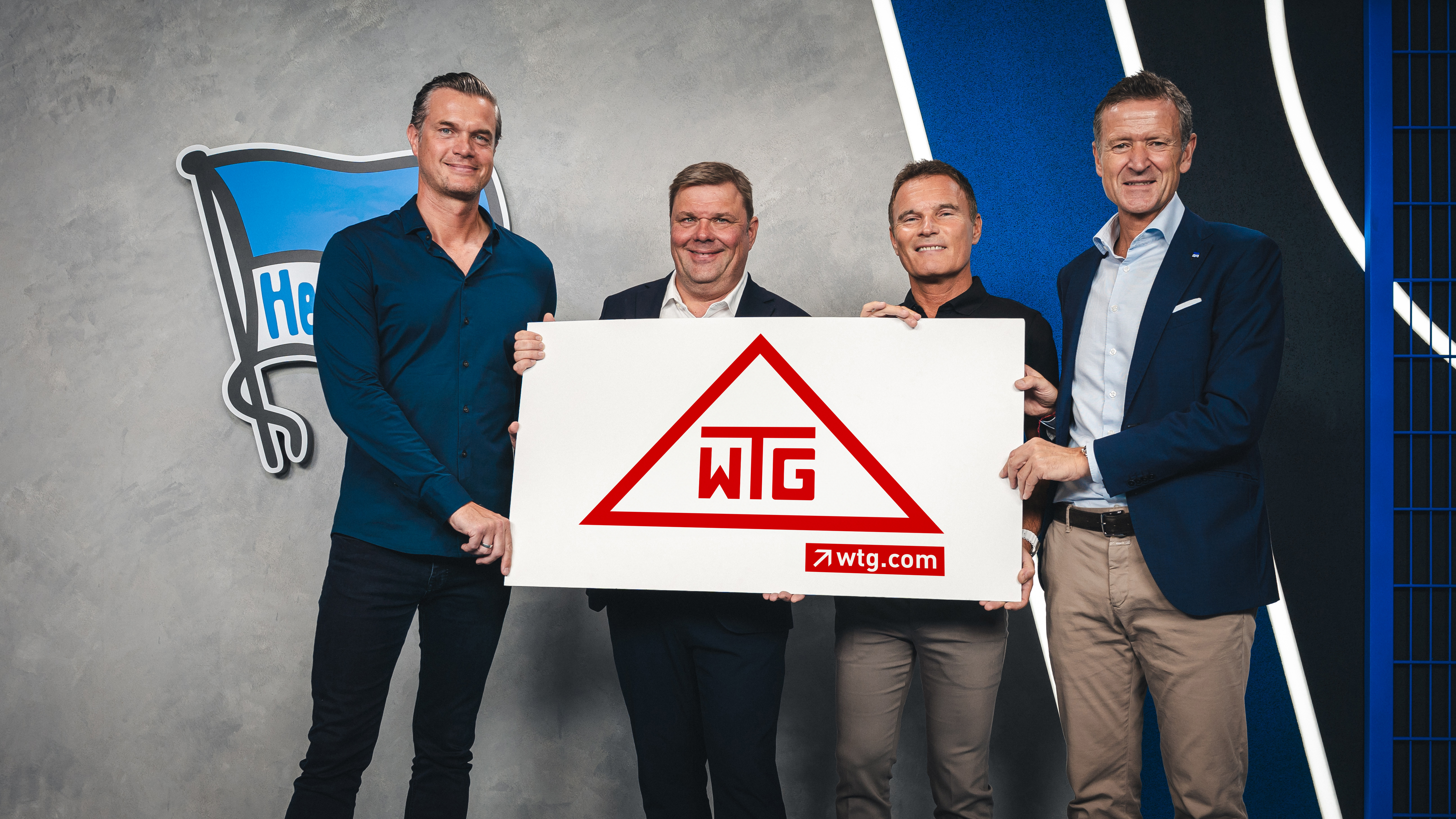 Vertreter von SPORTFIVE, der WTG und Hertha BSC posieren für ein Foto zur Partnerschaft.
