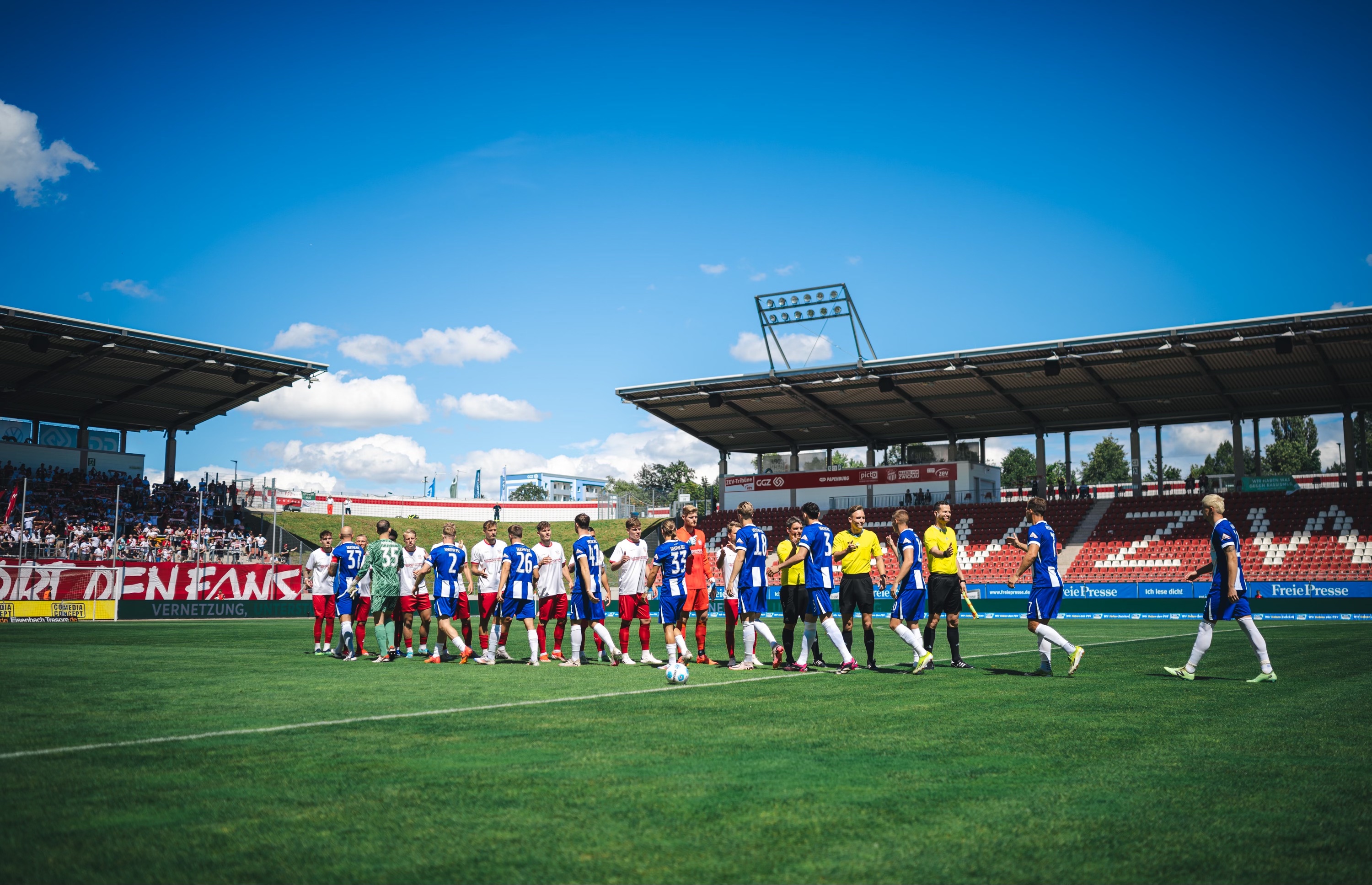 Blick in Stadion in Zwickau. Die Teams begrüßen sich.