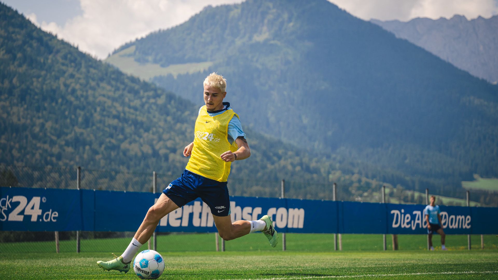 Marten Winkler treibt vor einem Bergpanoram den Ball nach vorne.