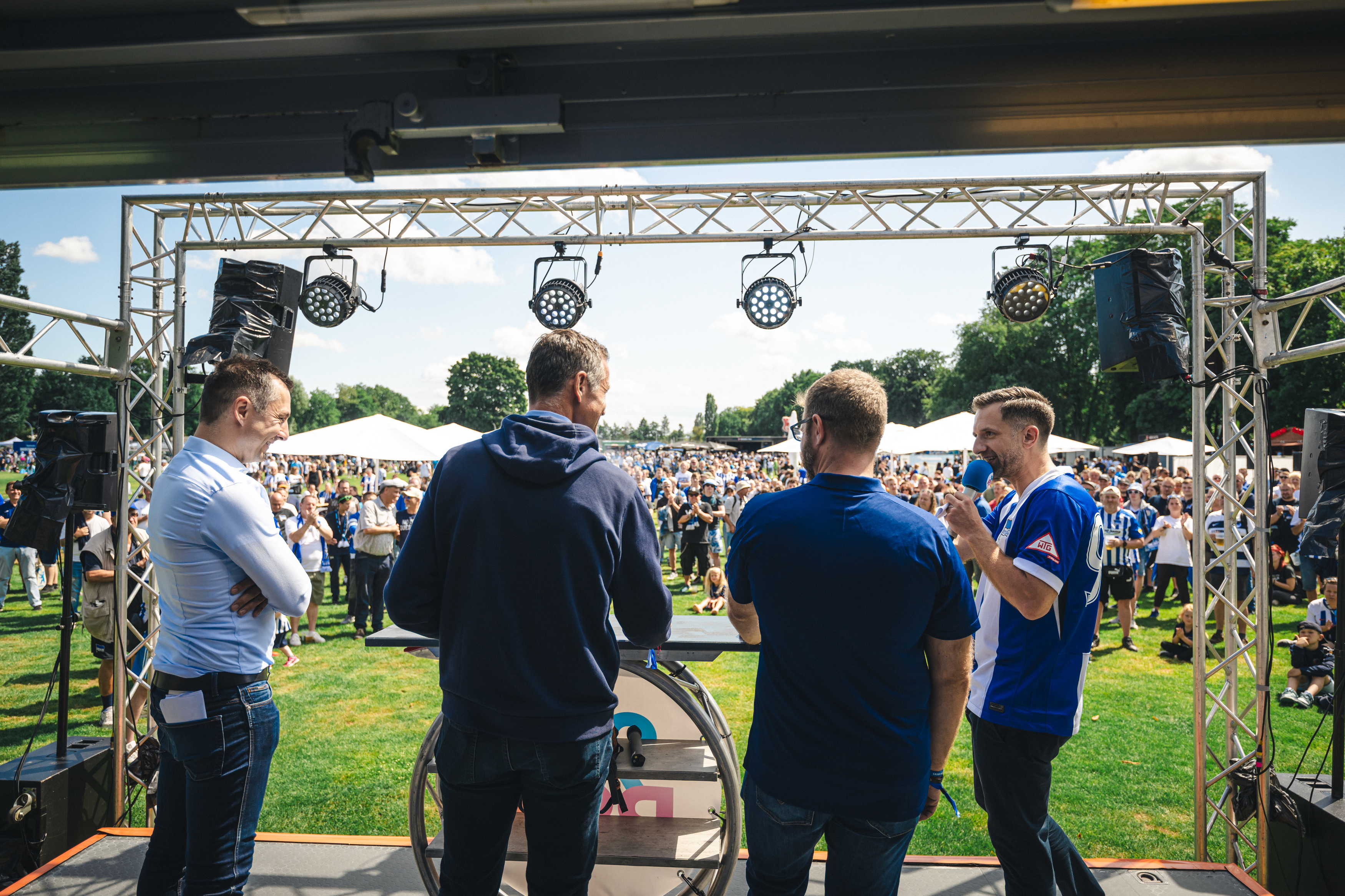 Ralf Huschen, Thomas E. Herrich und Fabian Drescher stehen auf der Bühne vor den Fans.