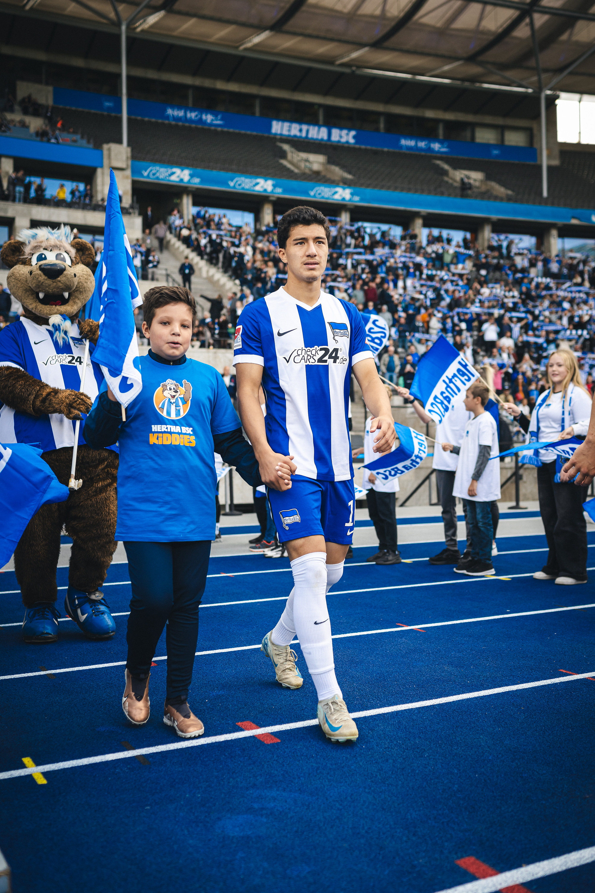 Ibrahim Maza betritt das Olympiastadion gemeinsam mit einem Einlaufkind.