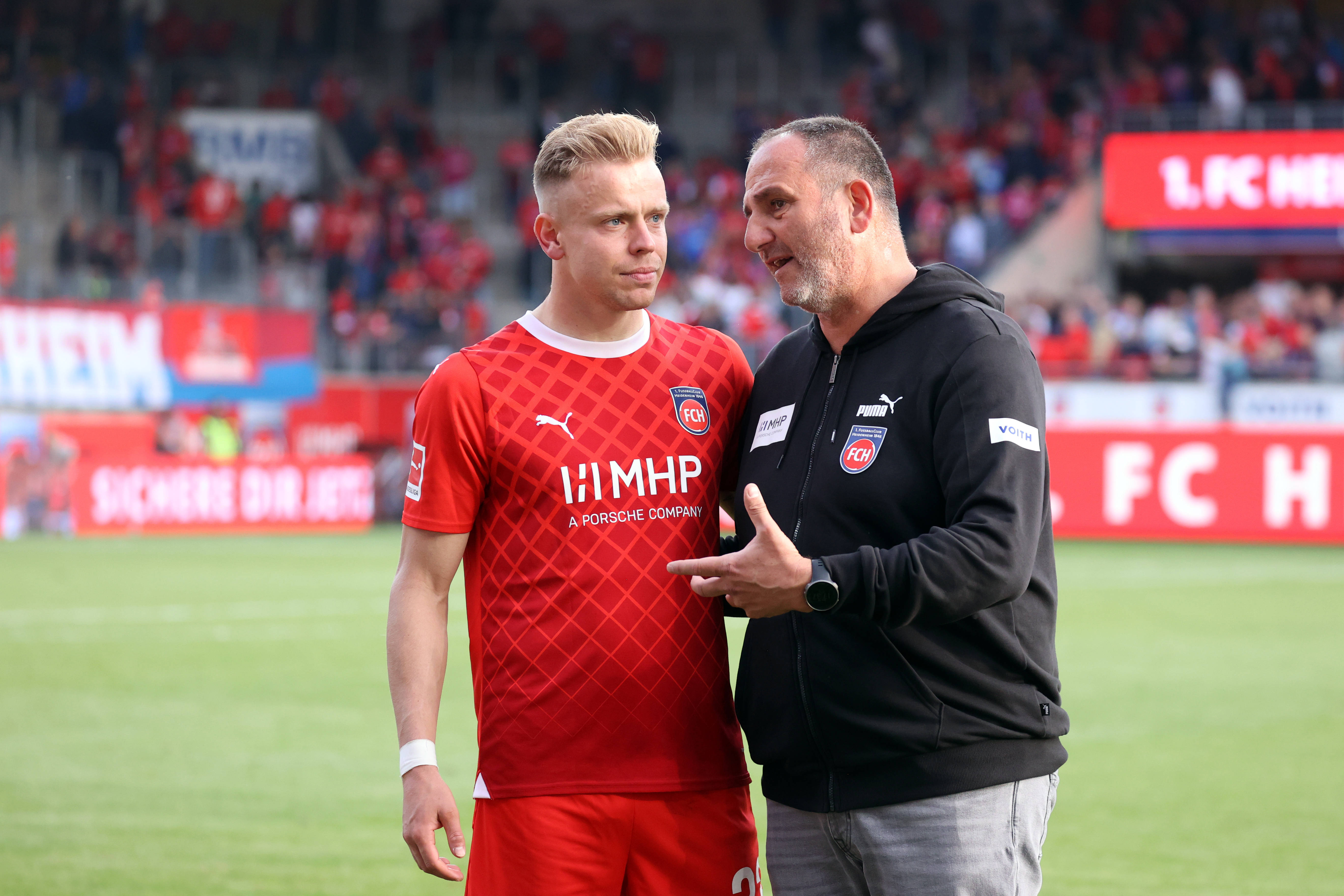 Lennard Maloney und Frank Schmidt besprechen sich auf dem Rasen.