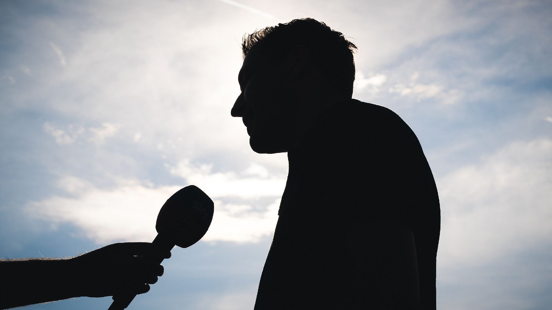 Benjamin Weber gibt, im Schatten stehend, ein Interview.