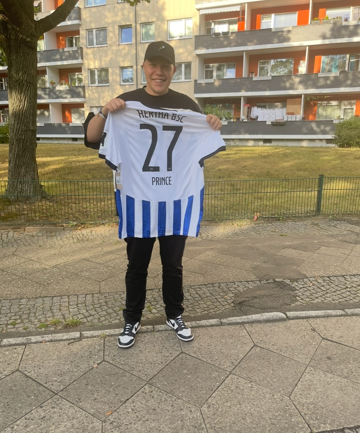 Sascha Fink hält ein Hertha-Trikot in den Händen.