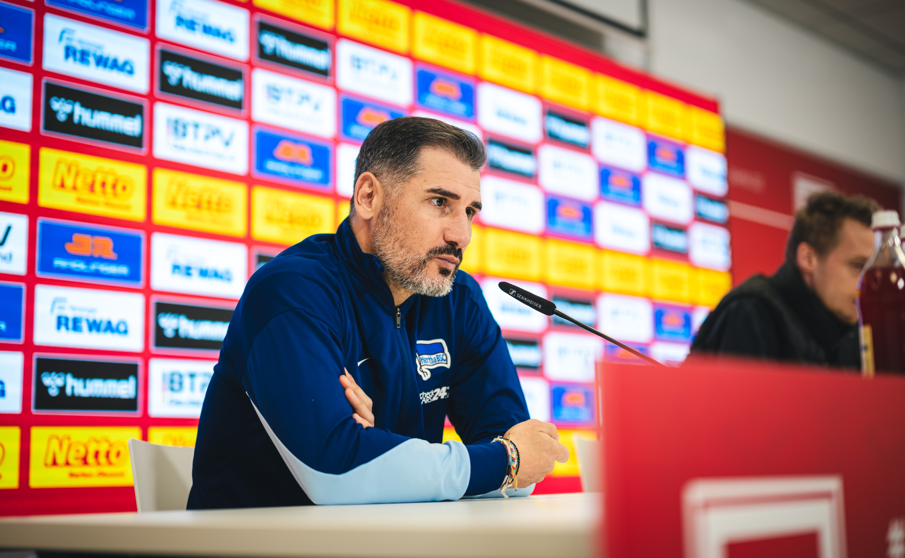 Cristian Fiél sitzt bei der Pressekonferenz auf dem Podium.