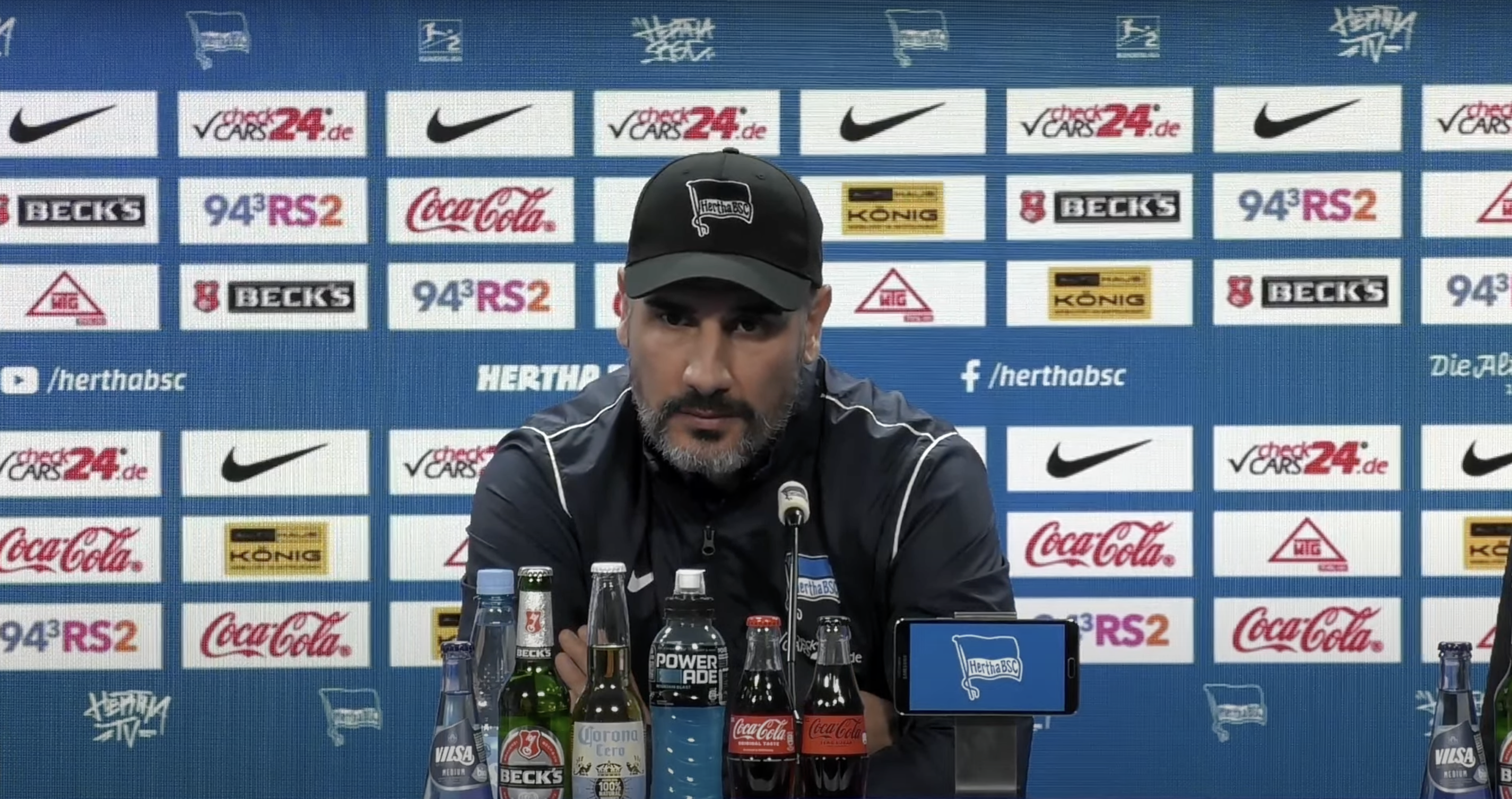 Cristian Fiél sitzt bei der Pressekonferenz auf dem Podium.