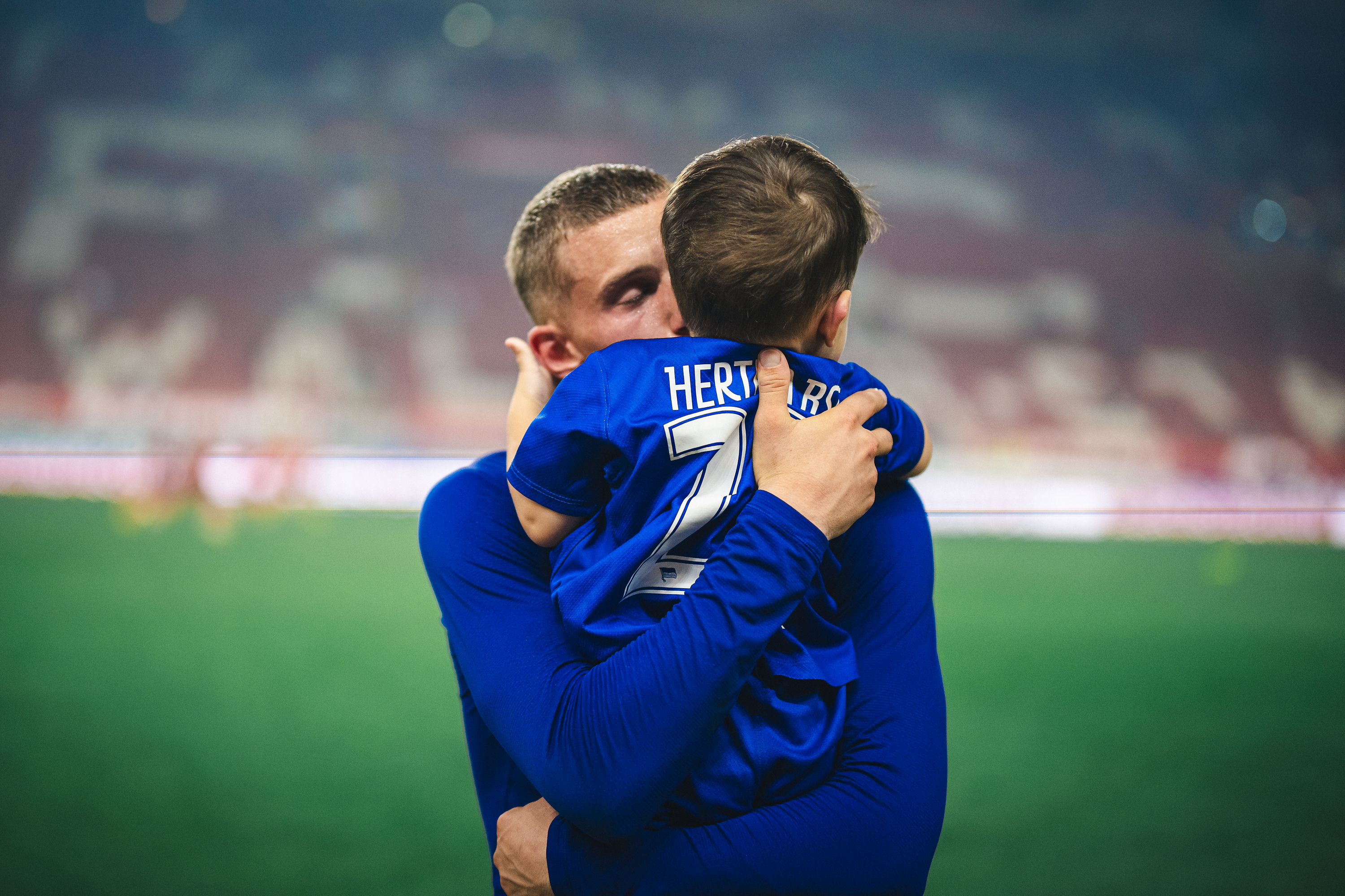 Michaël Cuisance genießt den Sieg in Kaiserslautern mit seinem Sohn auf dem Arm.