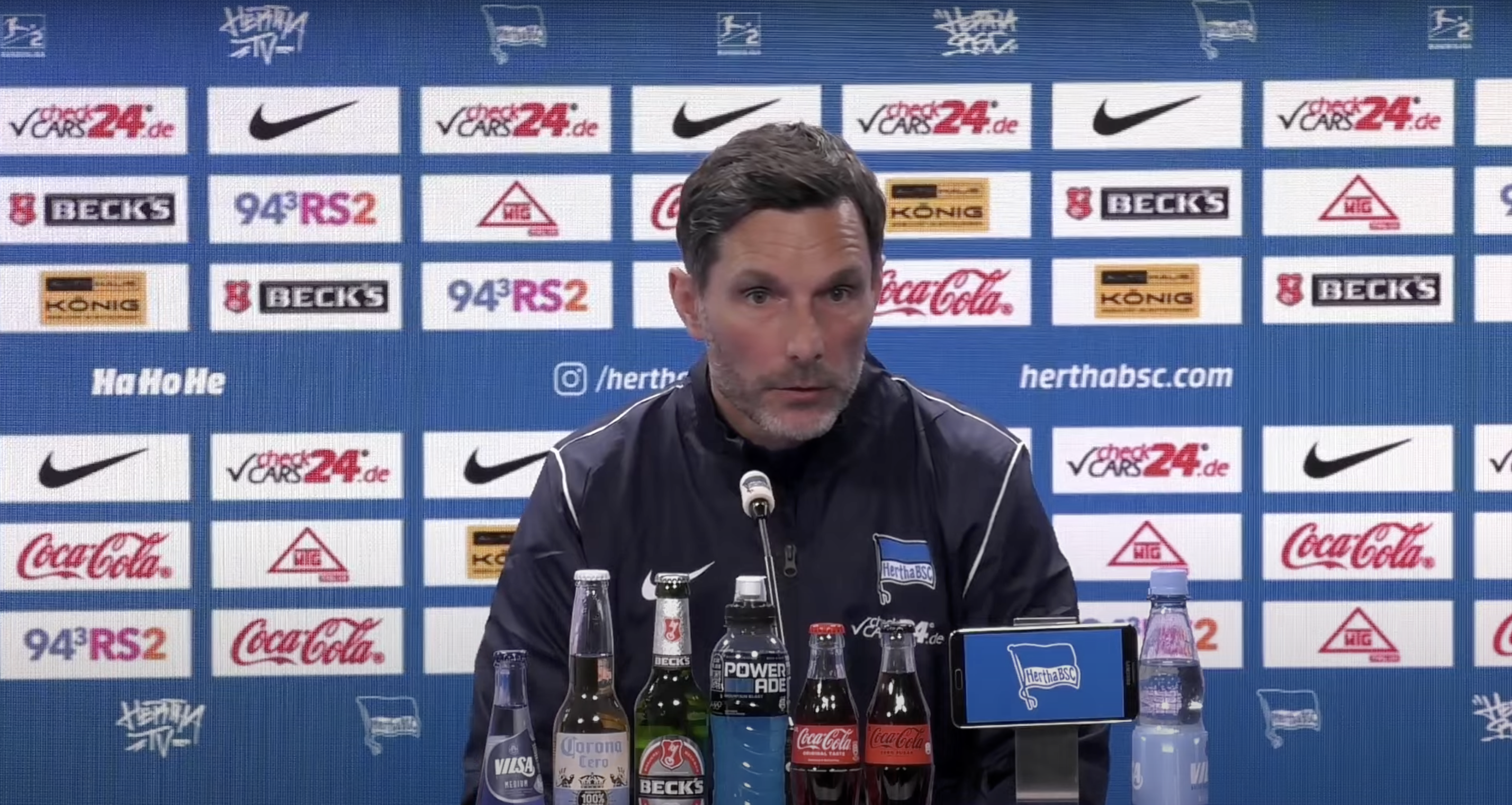 Stefan Leitl sitzt auf dem Podium bei der Pressekonferenz.