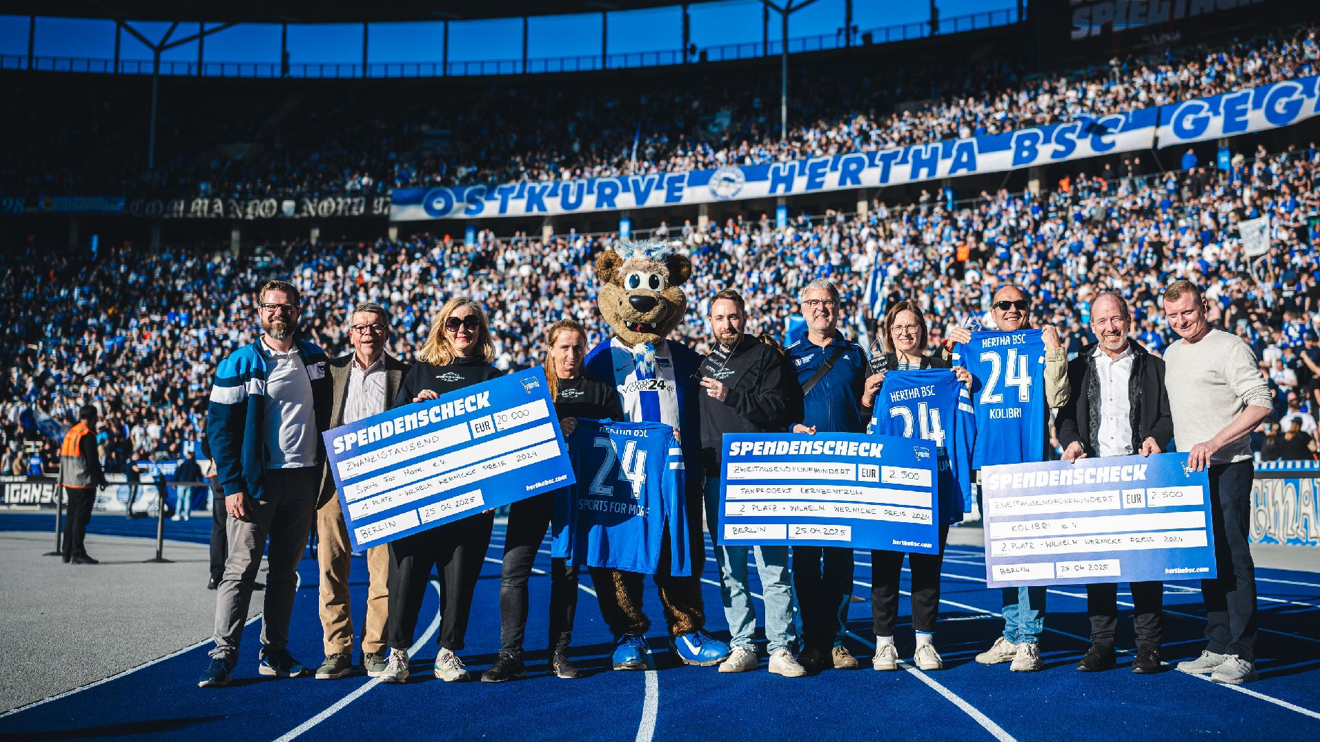 Die Gewinnerinnen und Gewinner des Wilhelm Wernicke Preises 2024 posieren mit Fabian Drescher, Bernd Schiphorst und Herthinho zum Gruppenfoto.