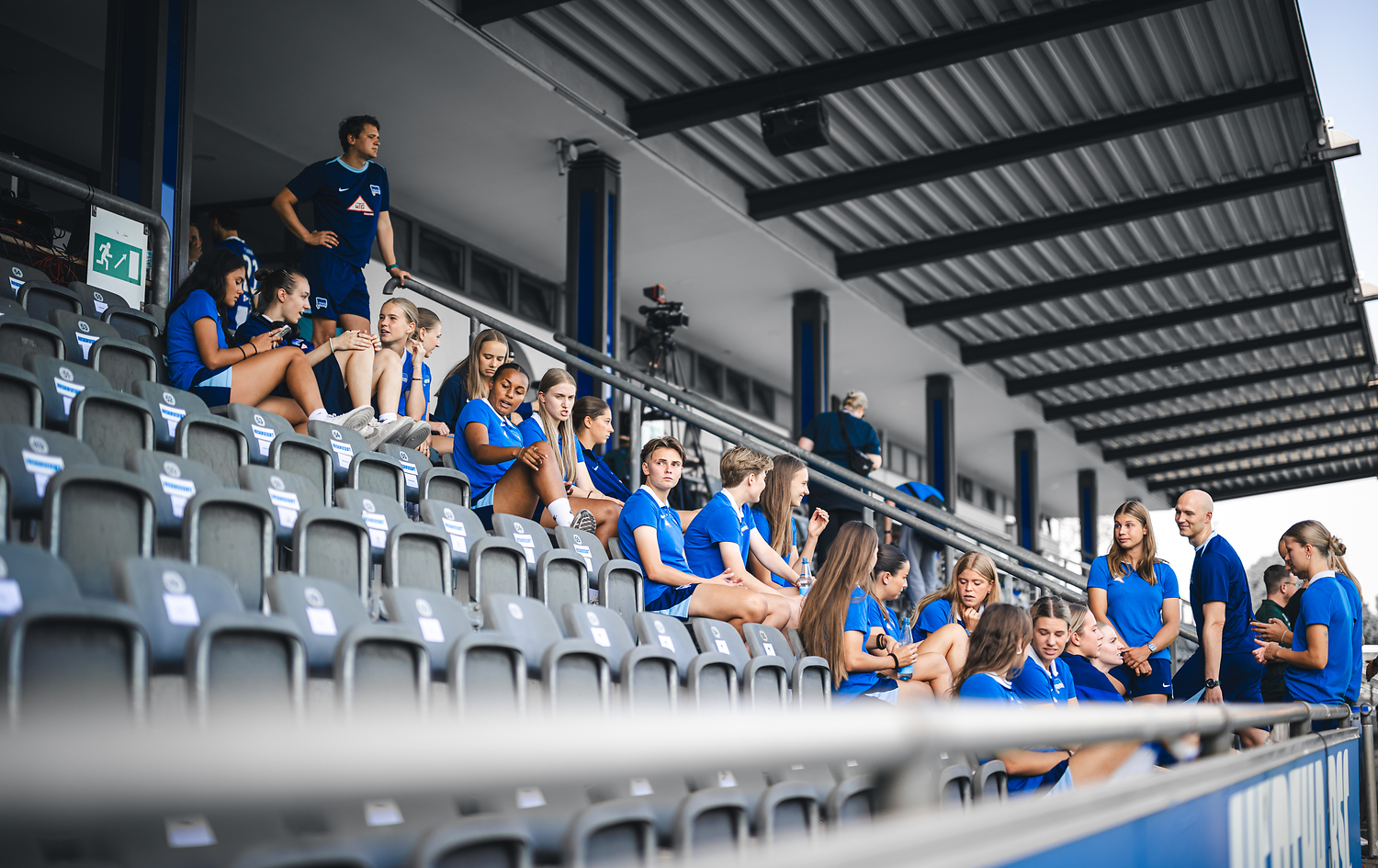 Unsere Frauen sitzen vor dem Spiel auf der Tribüne im Amateurstadion.