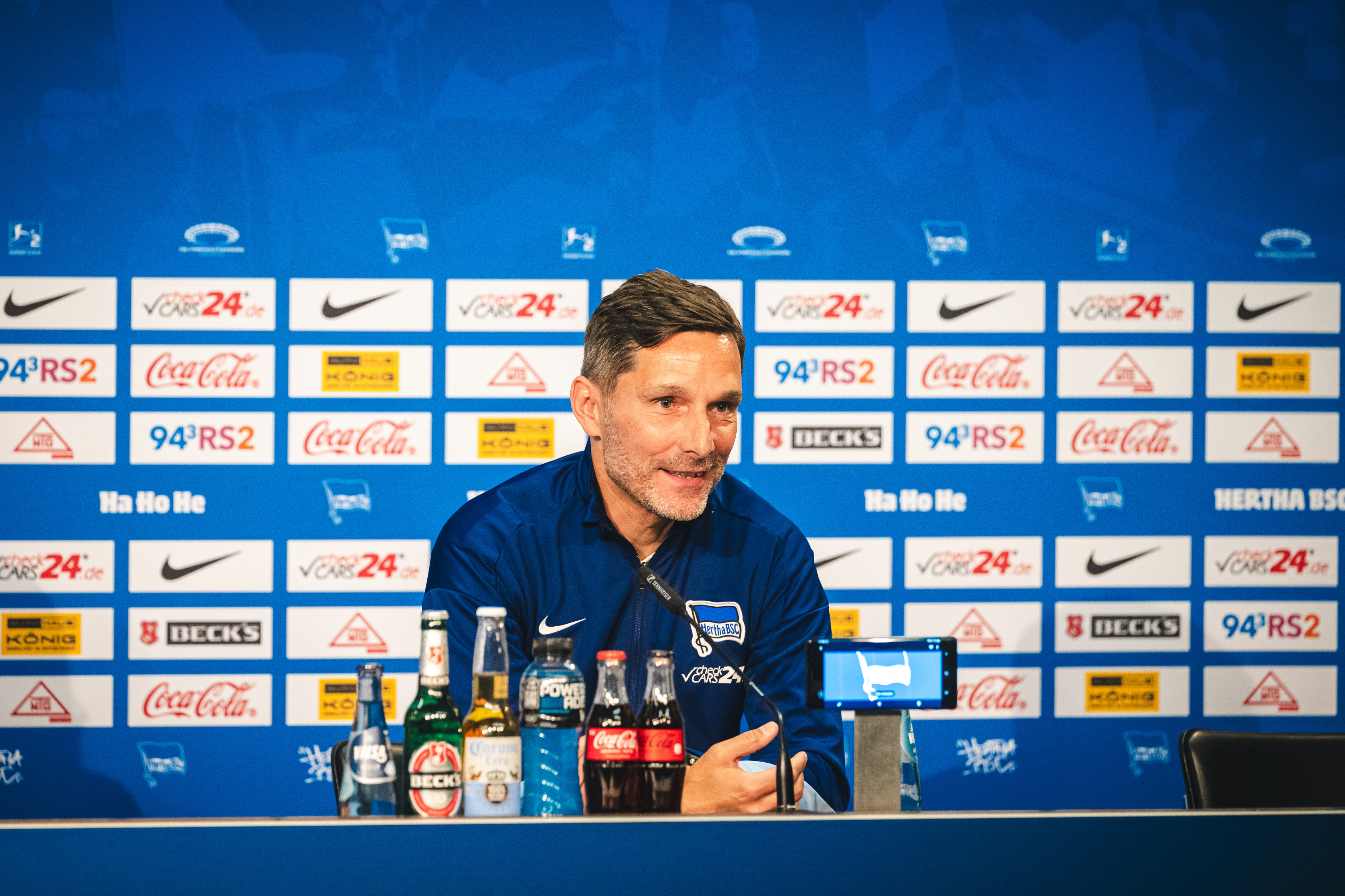 Stefan Leitl sitzt bei der Pressekonferenz auf dem Podium.