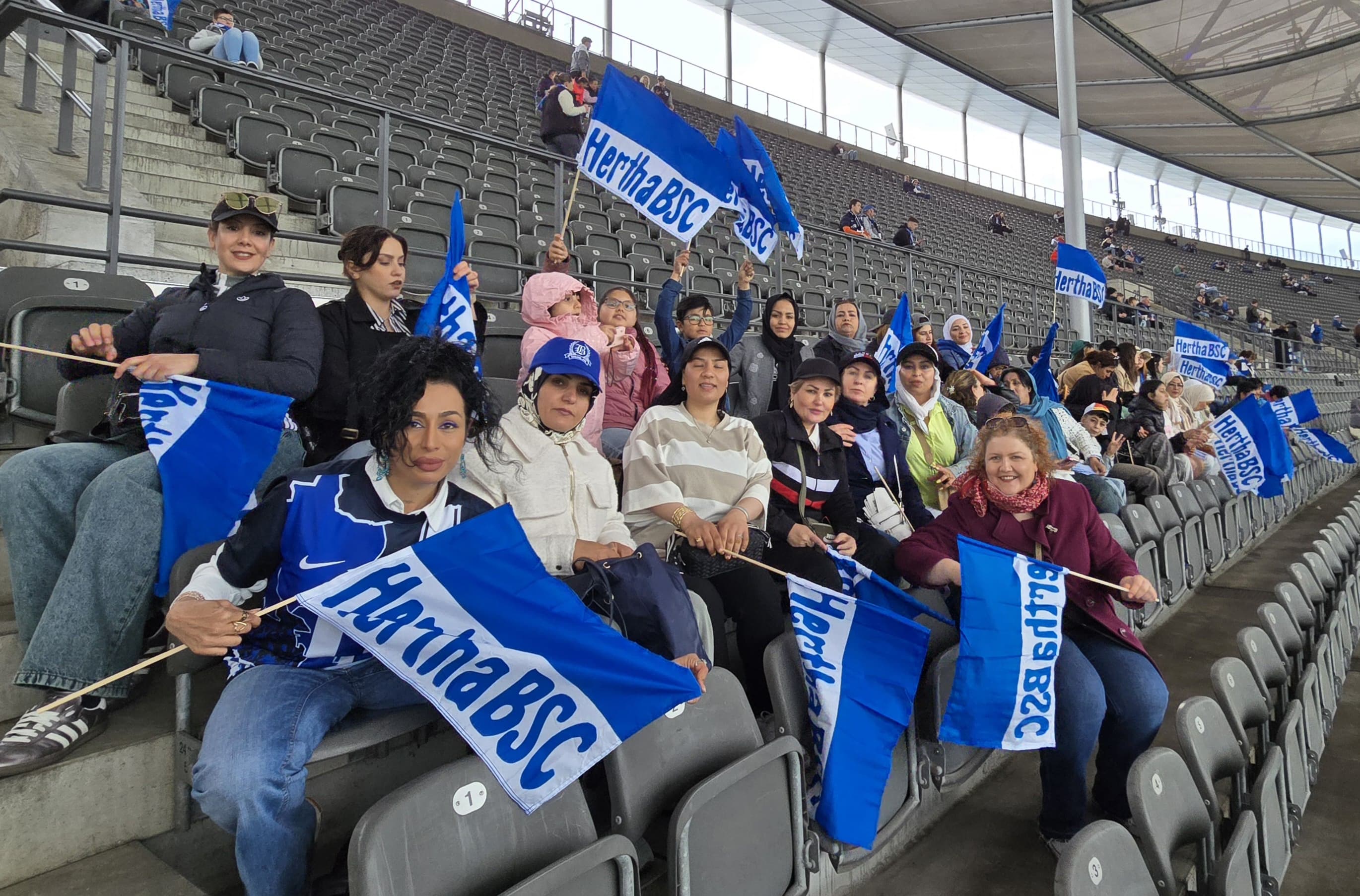 Die Gruppe von Frauen und Kindern auf der Tribüne im Olympiastadion.