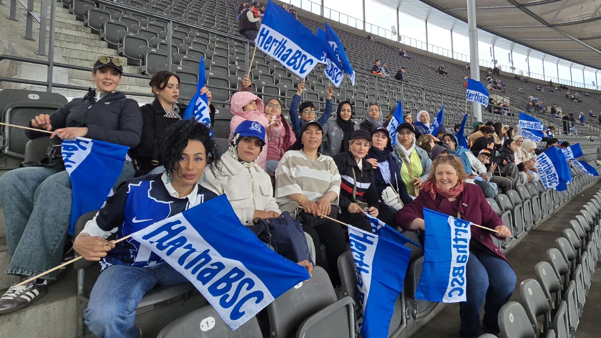 Die Gruppe von Frauen und Kindern auf der Tribüne im Olympiastadion.