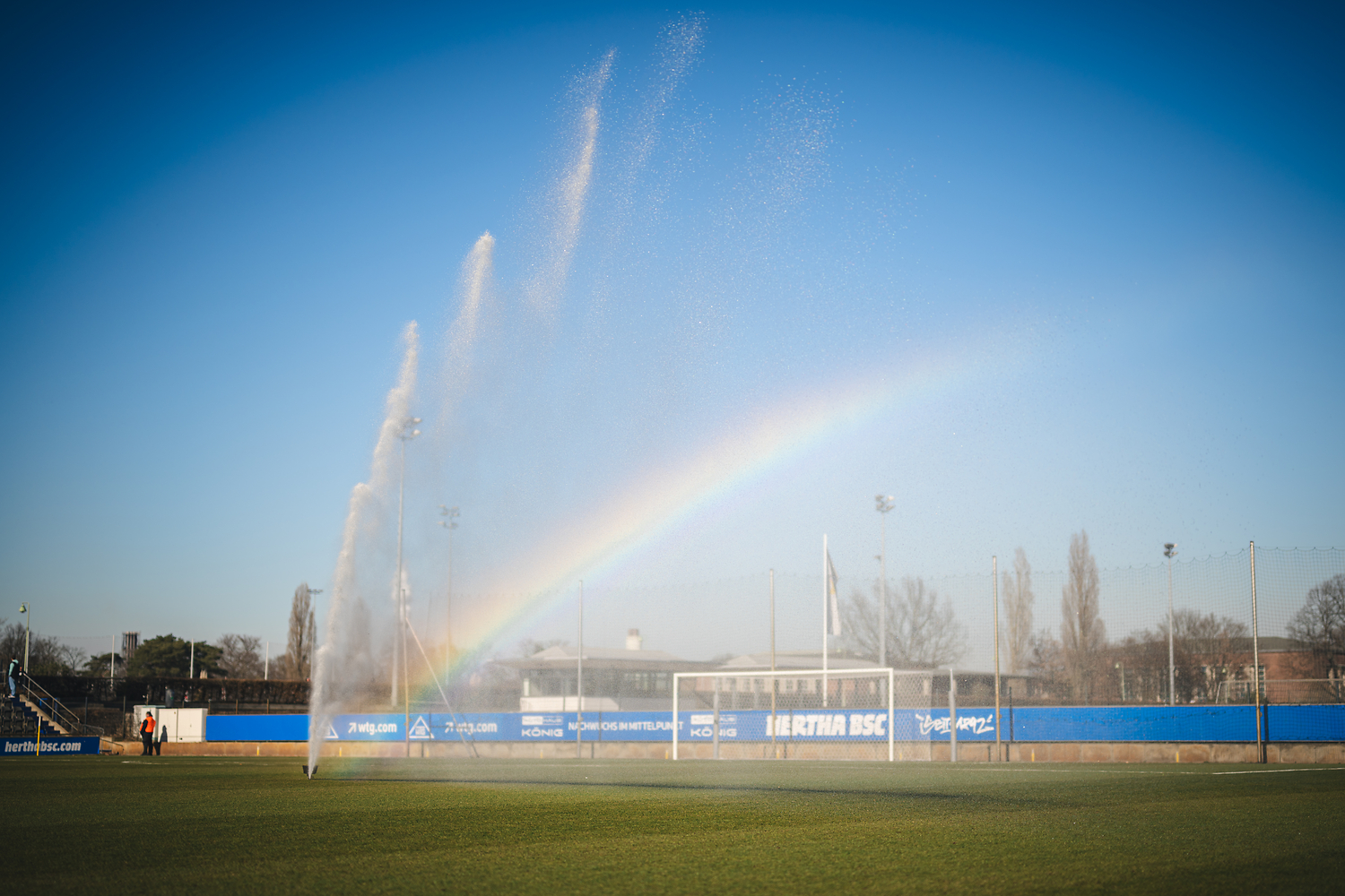 Ein Wassersprenger und ein Regenbogen im Stadion auf dem Wurfplatz/Amateurstadion.