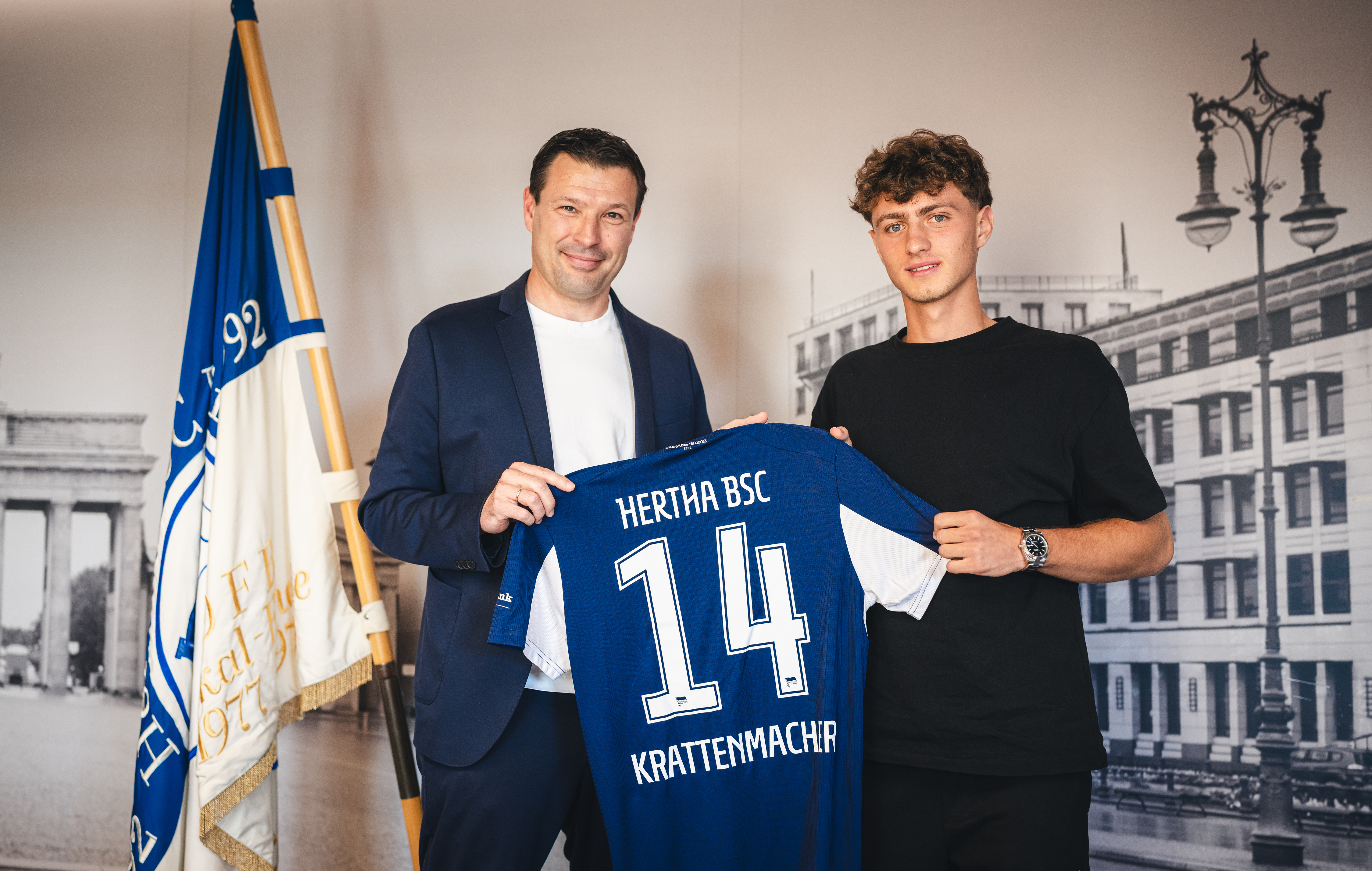 Benjamin Weber und Maurice Krattenmacher halten ein Trikot in die Höhe.
