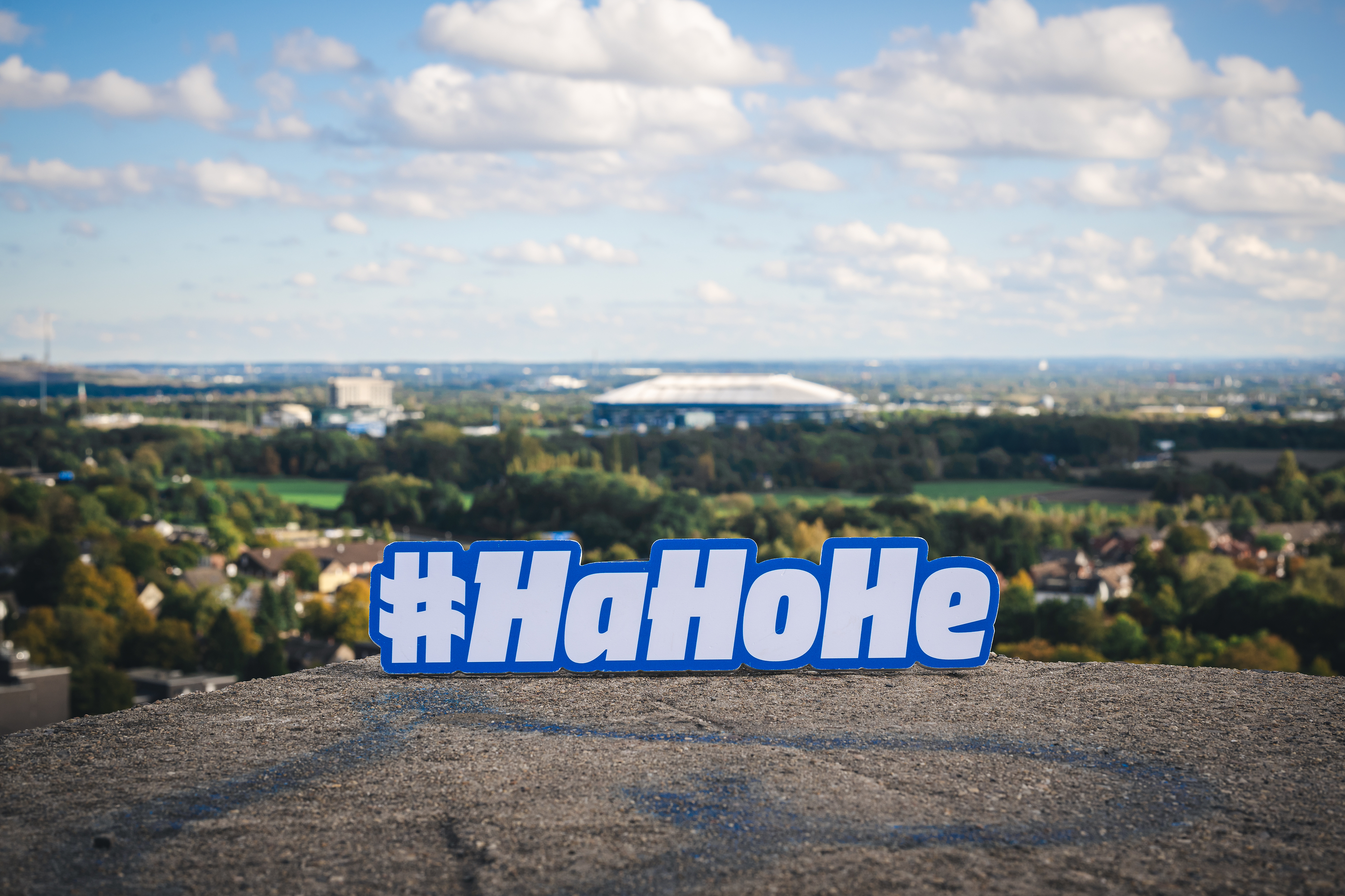Das HaHoHe-Schild auf einem Berg mit Blick auf die VELTINS-Arena auf Schalke.