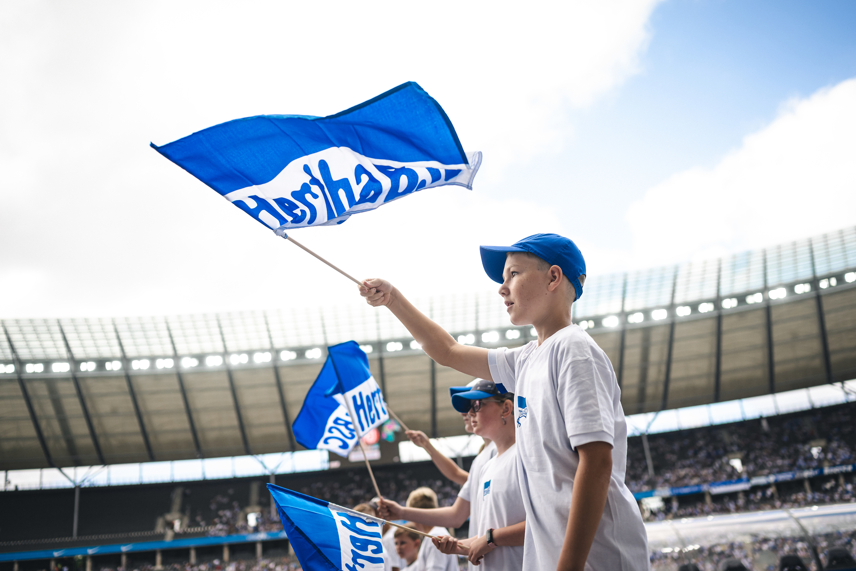 Ein Kind mit einer wehenden Fahne im Olympiastadion.