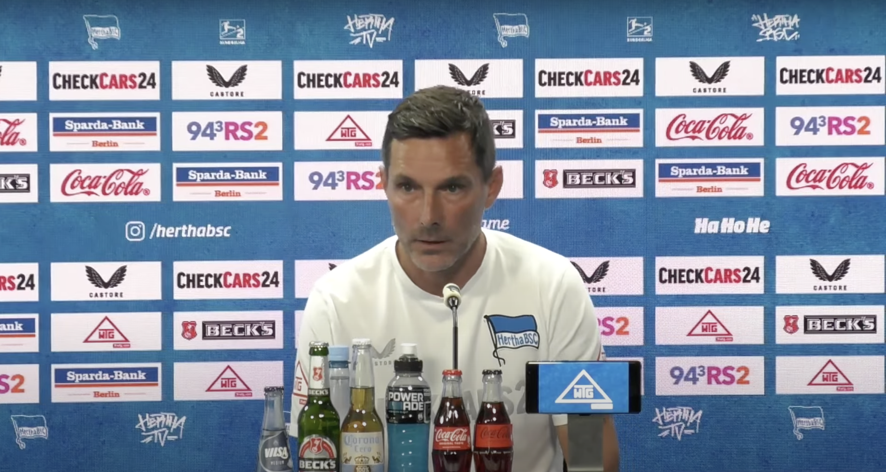 Stefan Leitl sitzt bei der Pressekonferenz auf dem Podium.