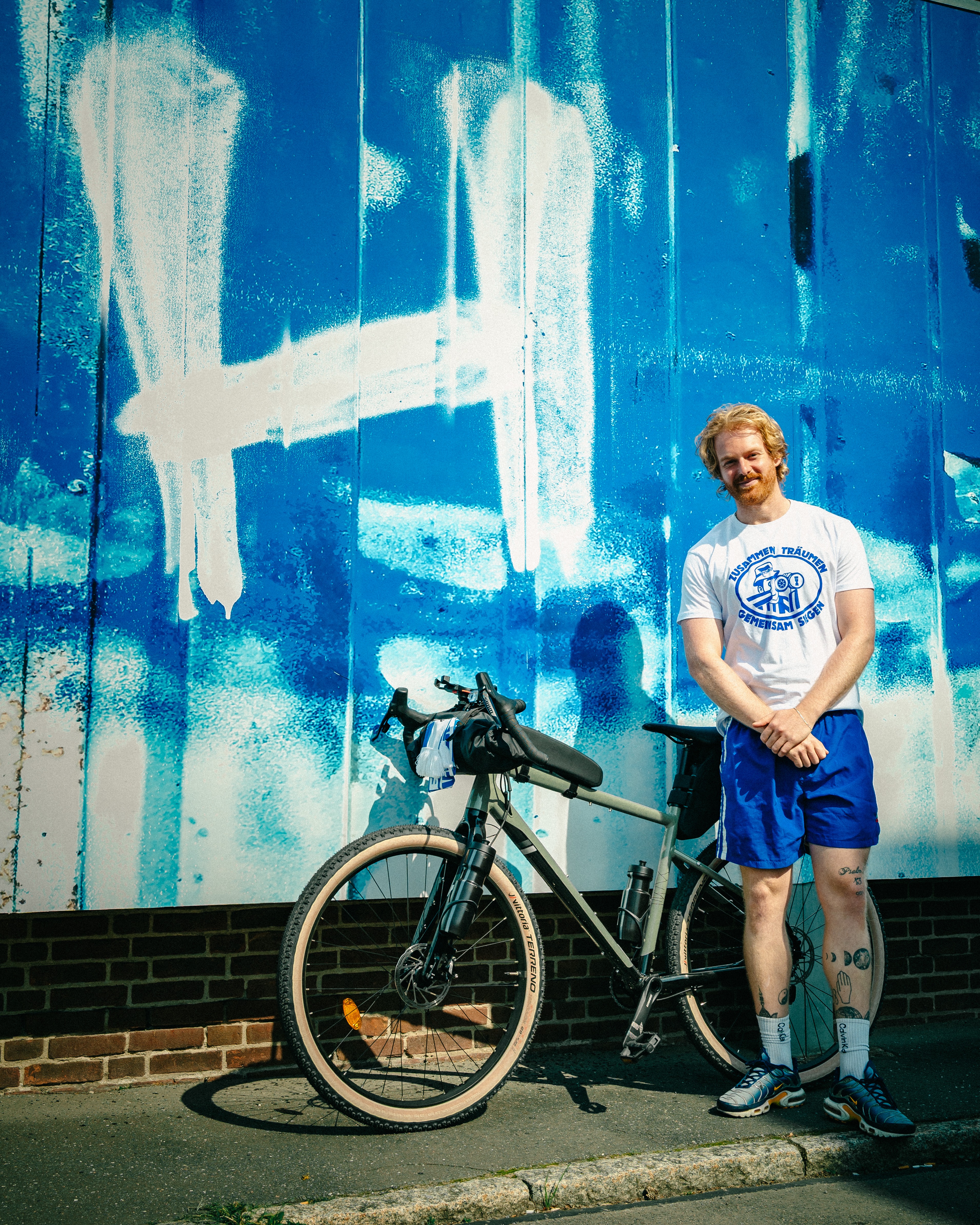 Jack Morris steht mit dem Fahrrad vor dem Welcome-Board an der Geschäftsstelle.