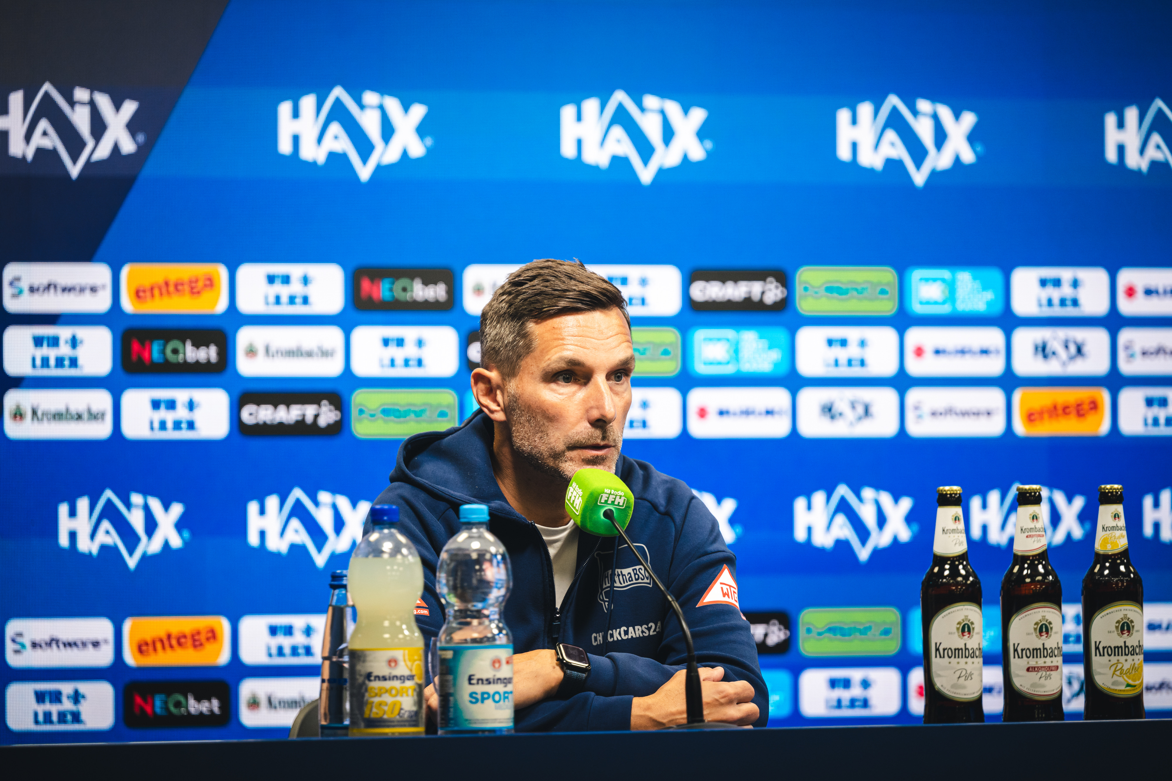 Stefan Leitl sitzt bei der Pressekonferenz auf dem Podium.