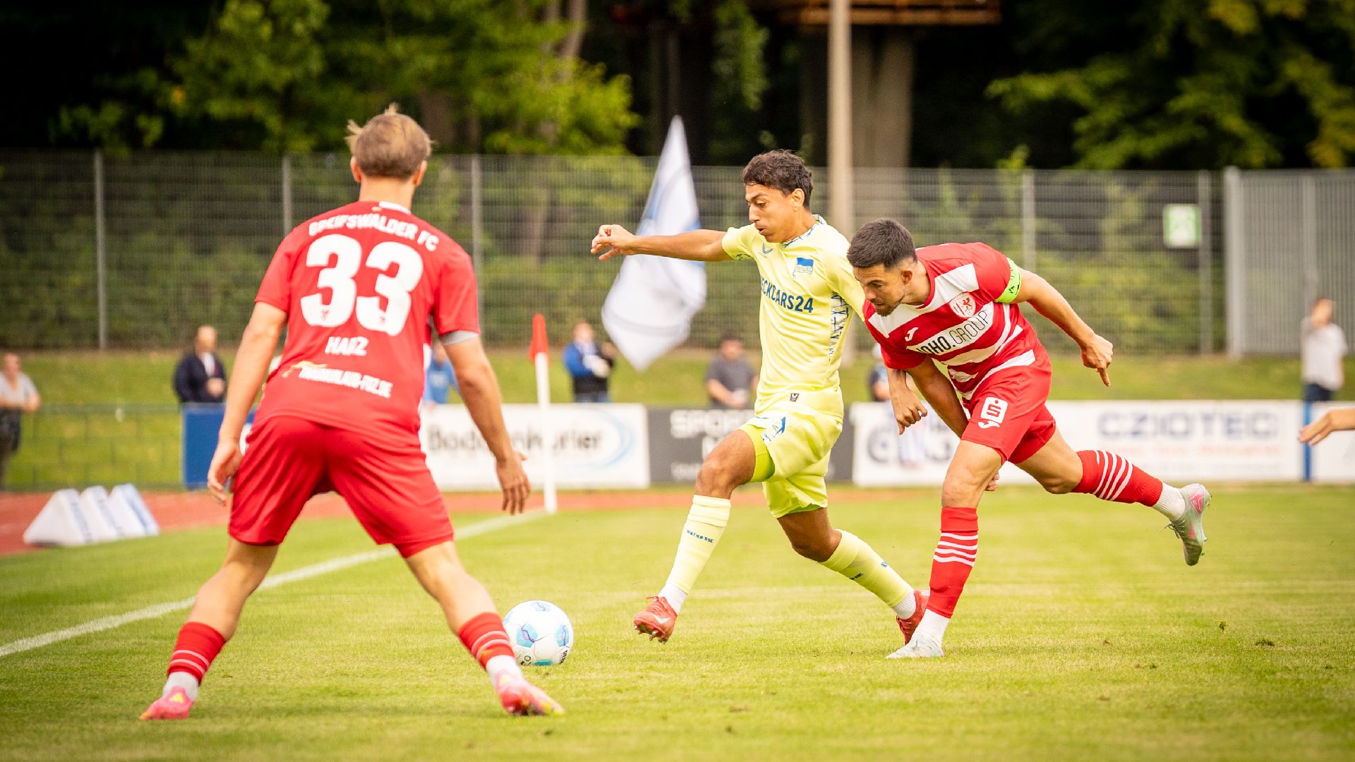 Eliyas Strasner im Zweikampf mit zwei Greifswalder Gegenspielern.