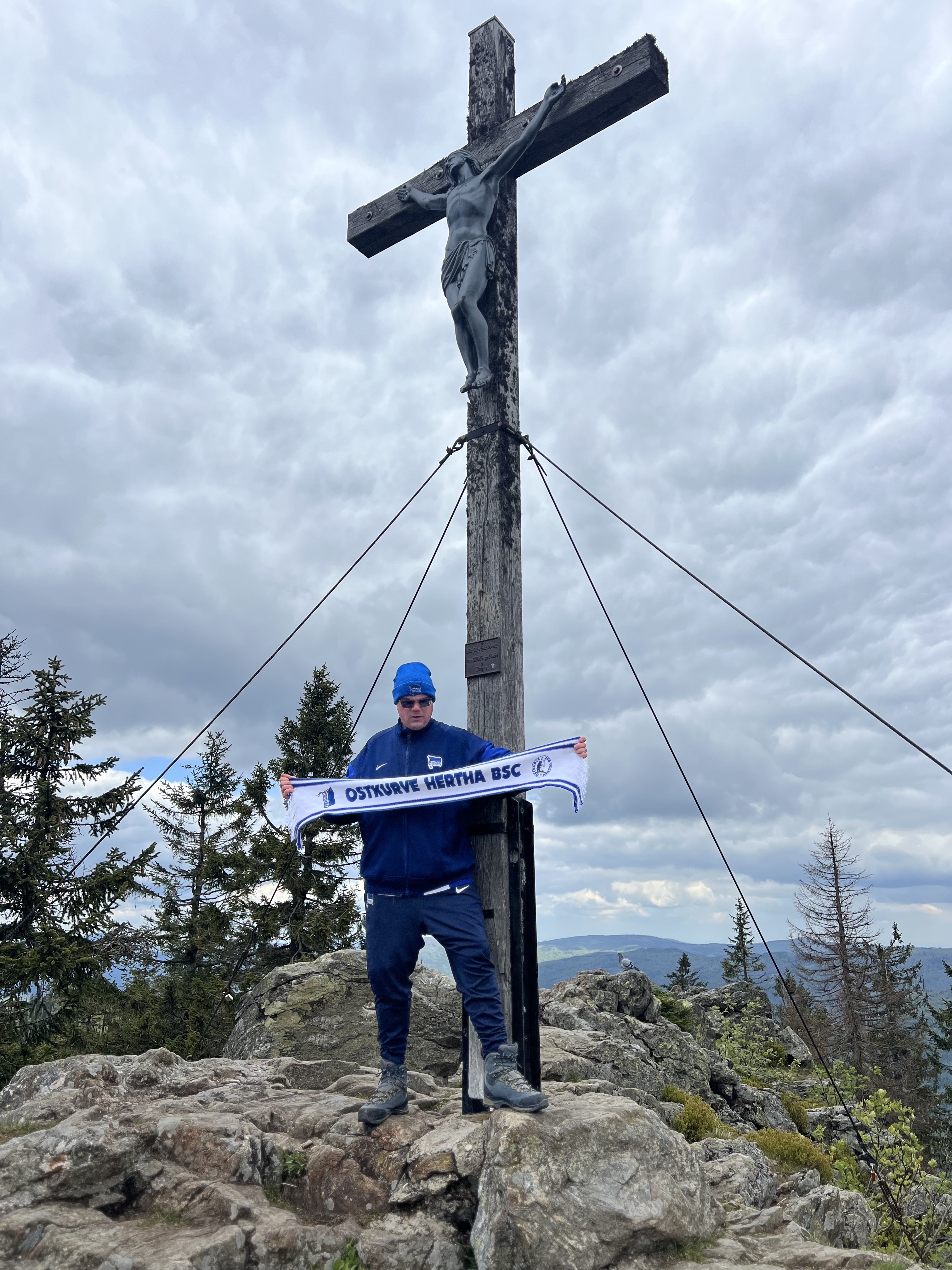 Christian Deppisch in Hertha-Kleidung am Gipfelkreuz.