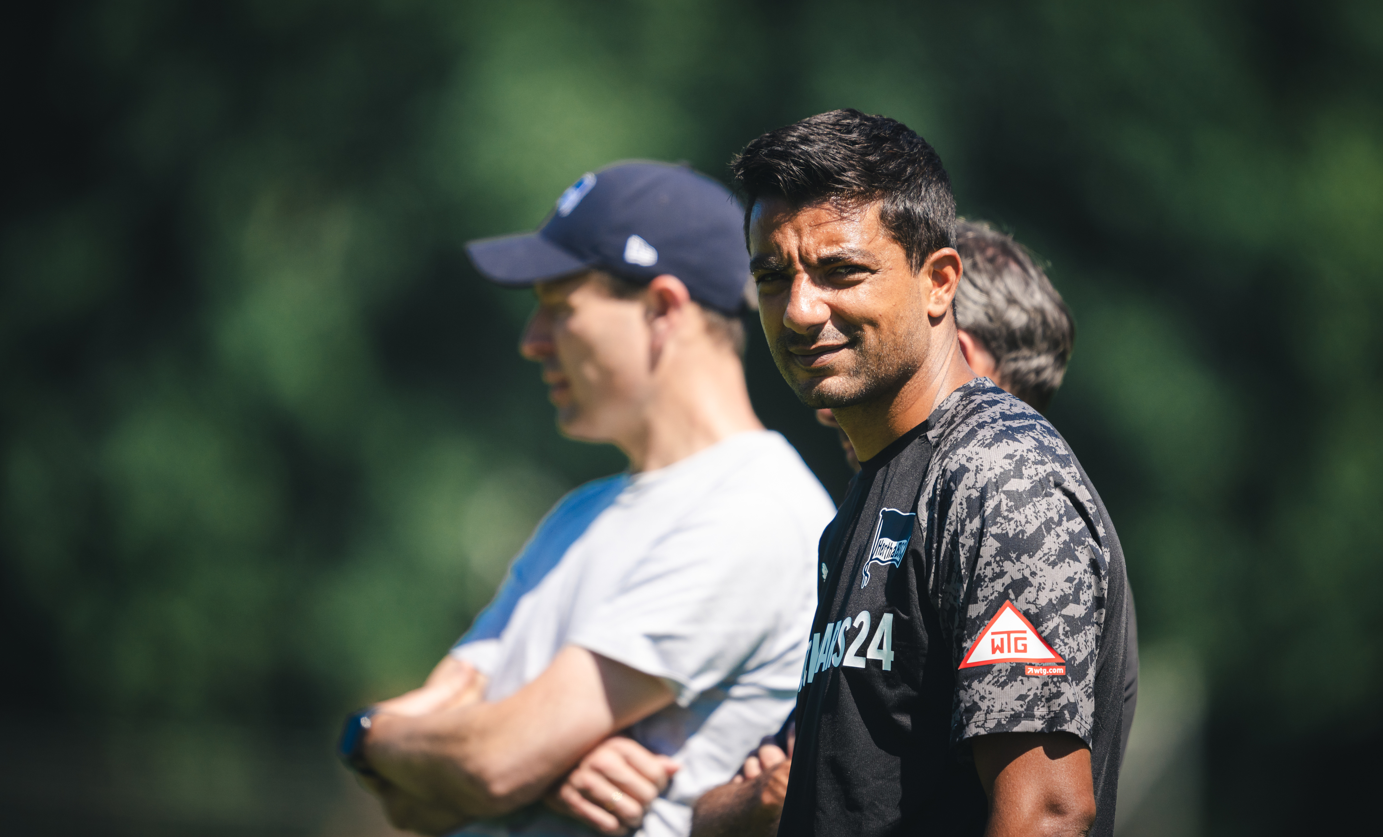 Sami Allagui lächelt in die Kamera. Im Hintergrund ist neben ihm Benjamin Weber zu sehen.
