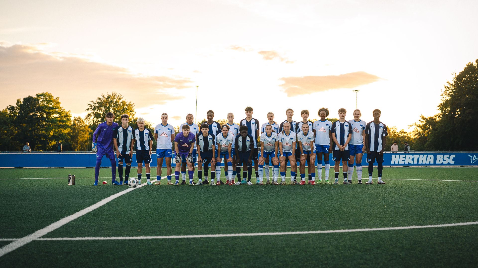 Unsere 1. Frauen und die U15 posieren für ein gemeinsames Foto.