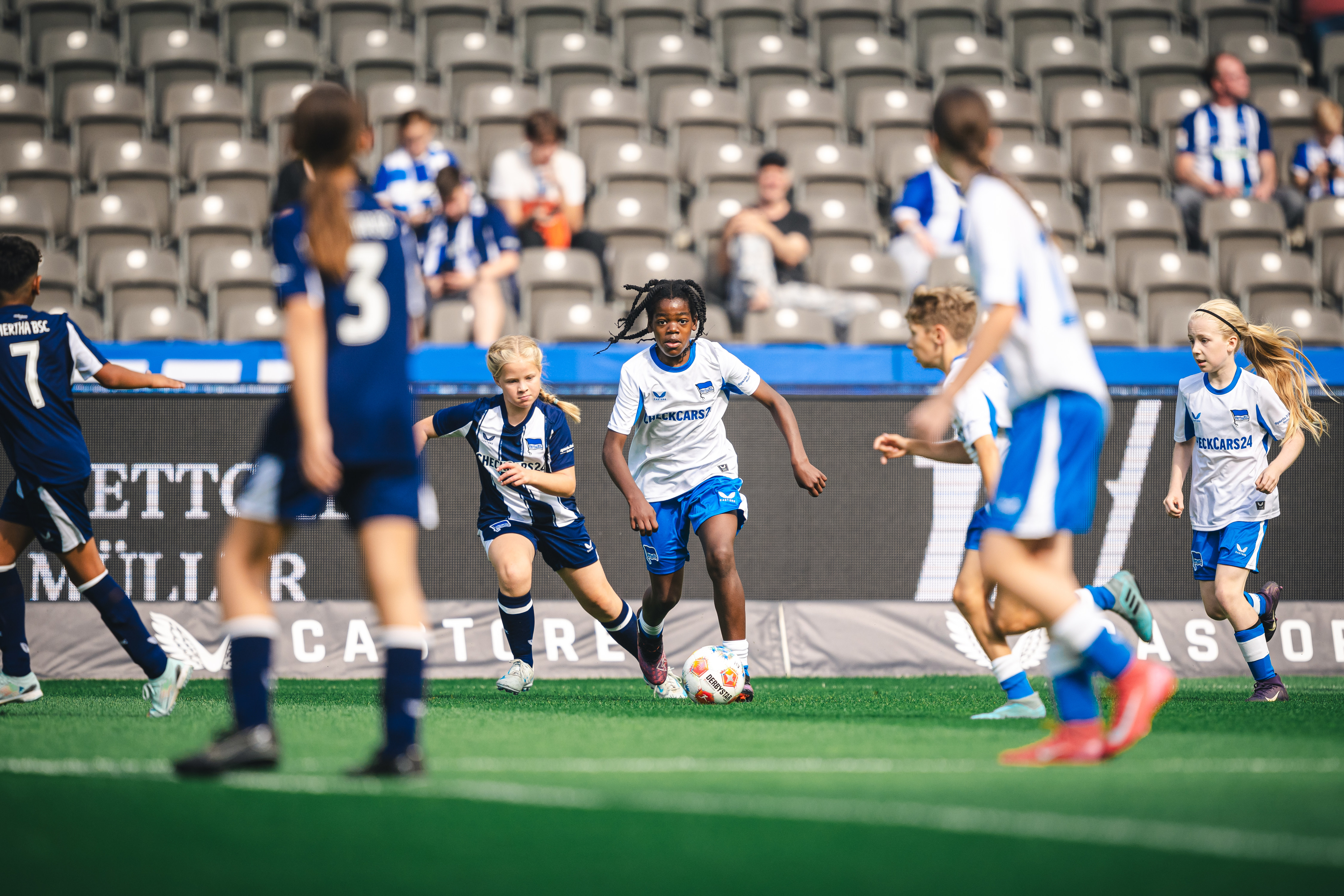 Ein Zweikampf zwischen zwei Kids auf dem Rasen des Olympiastadions.