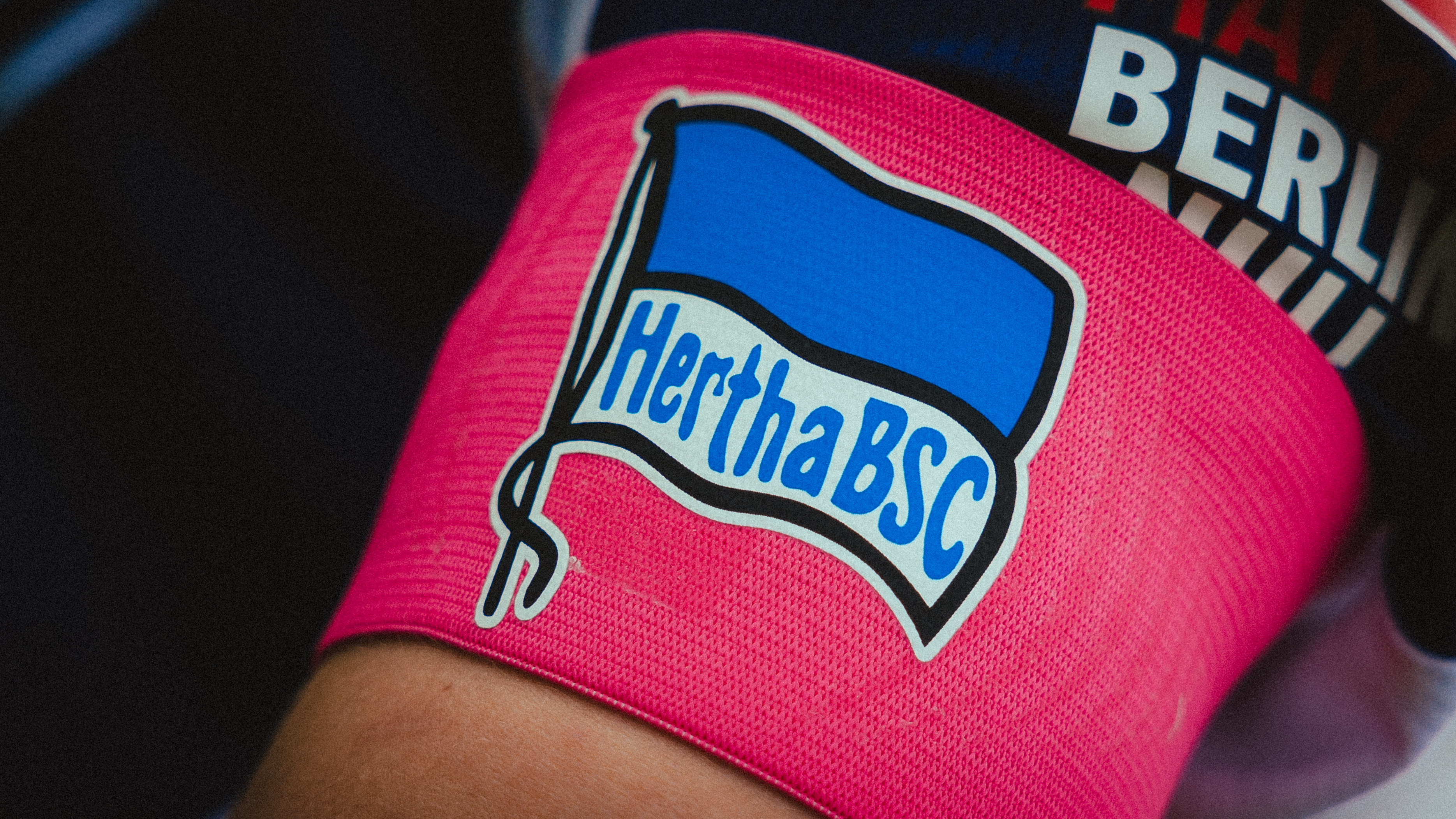 Eine pinke Kapitänsbinde mit der Hertha-Fahne.