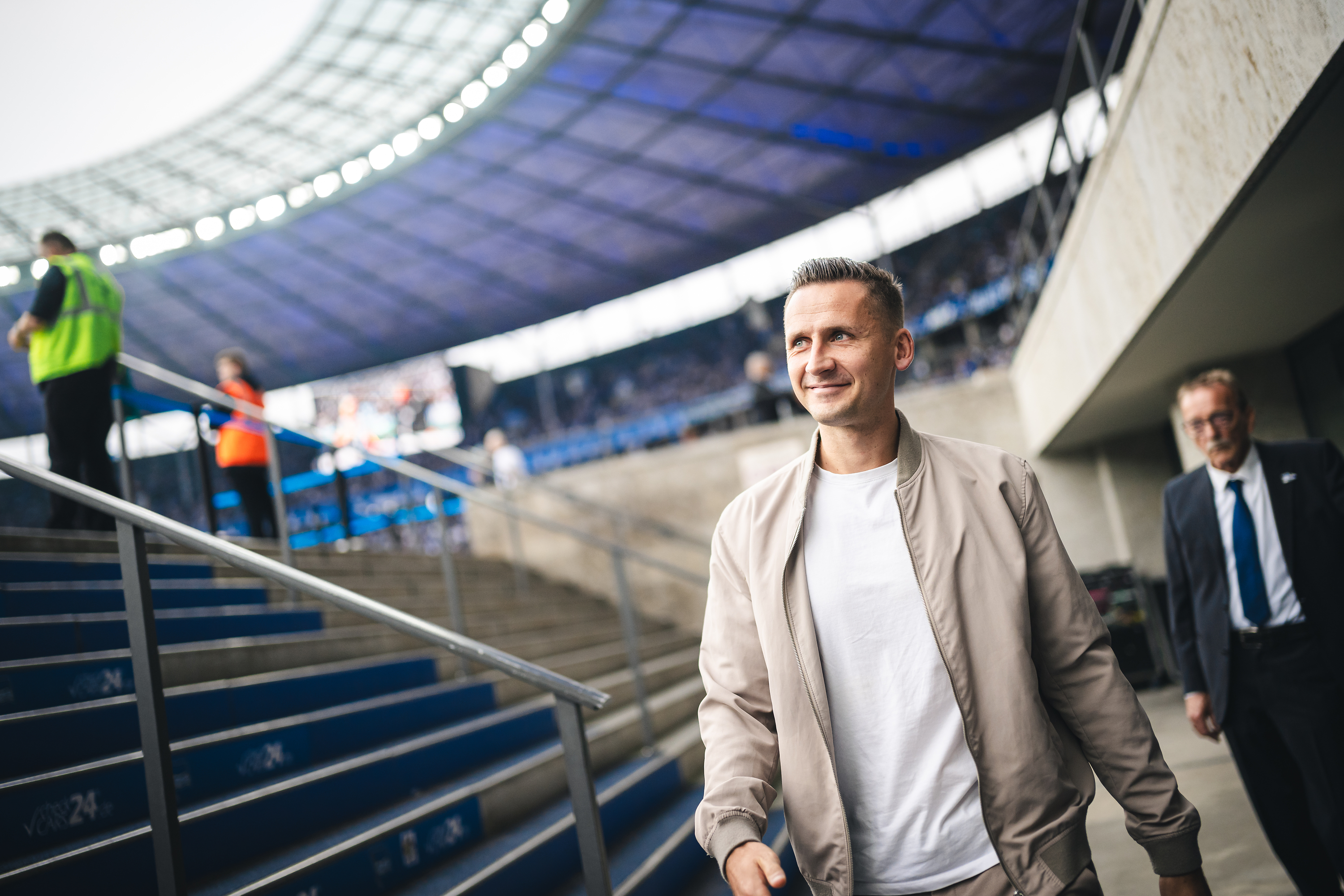 Paul Seguin geht in ziviler Kleidung durch das Olympiastadion.