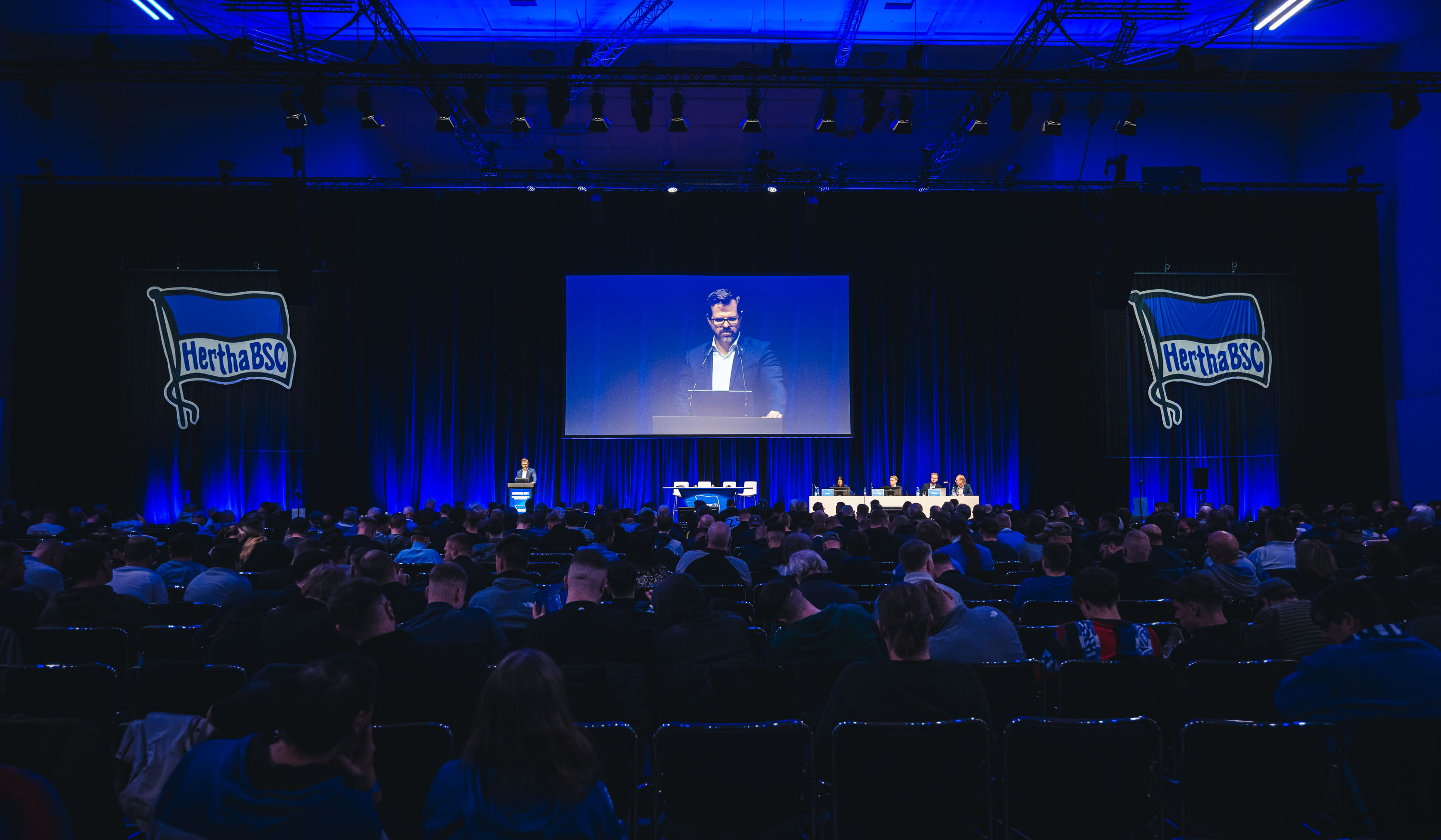 Fabian Drescher steht vor der Mitgliederversammlung auf dem Podium.