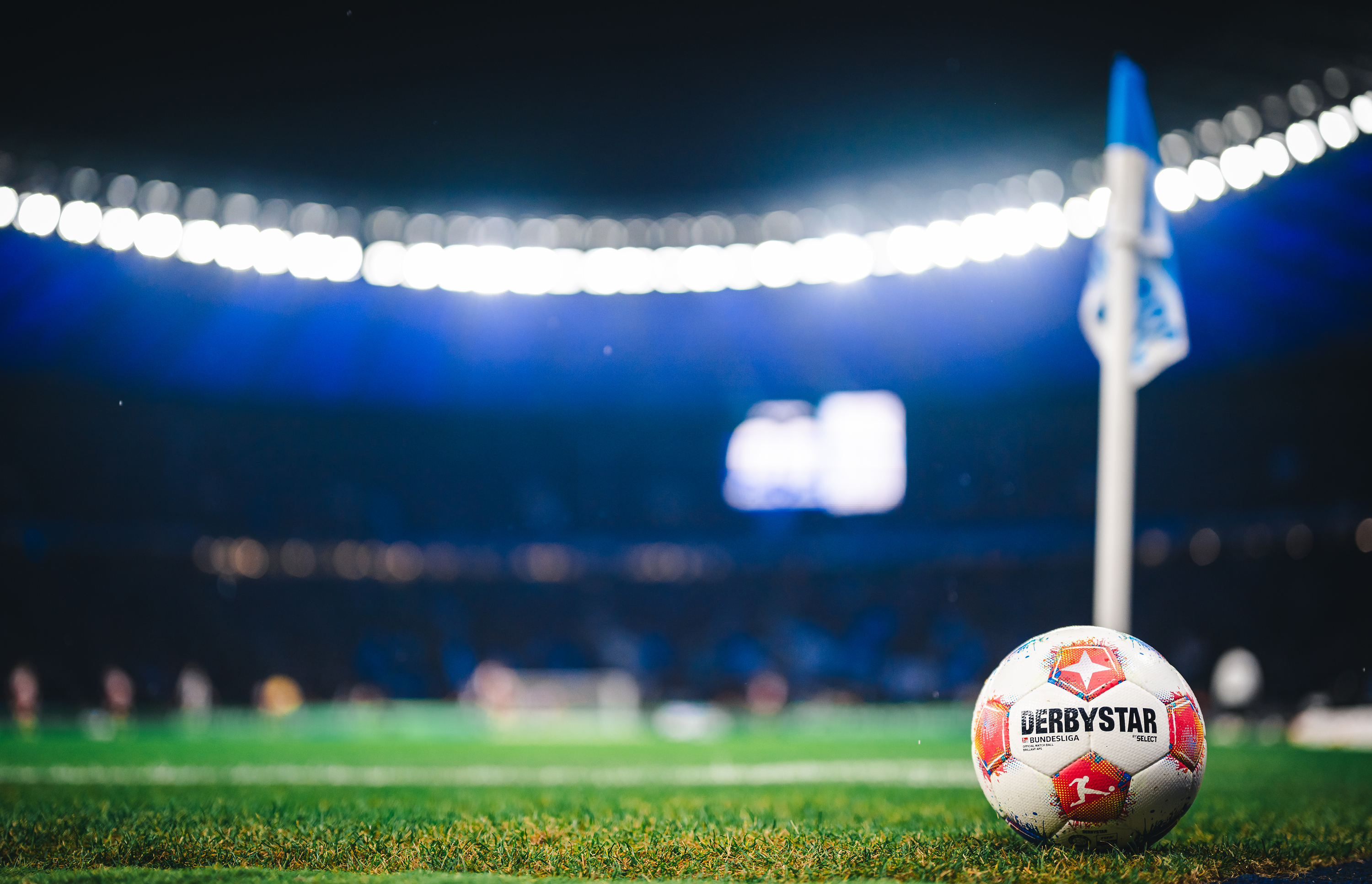 Der Bundesligaspielball liegt auf dem Rasen im flutlichtüberströmten Olympiastadion.