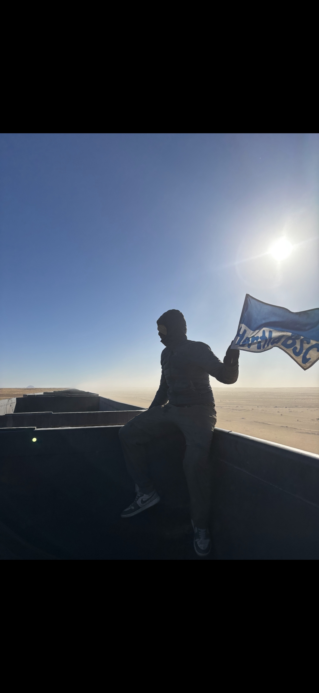 Einer der beiden Jungs mit der Herthafahne auf einem Güterzug.