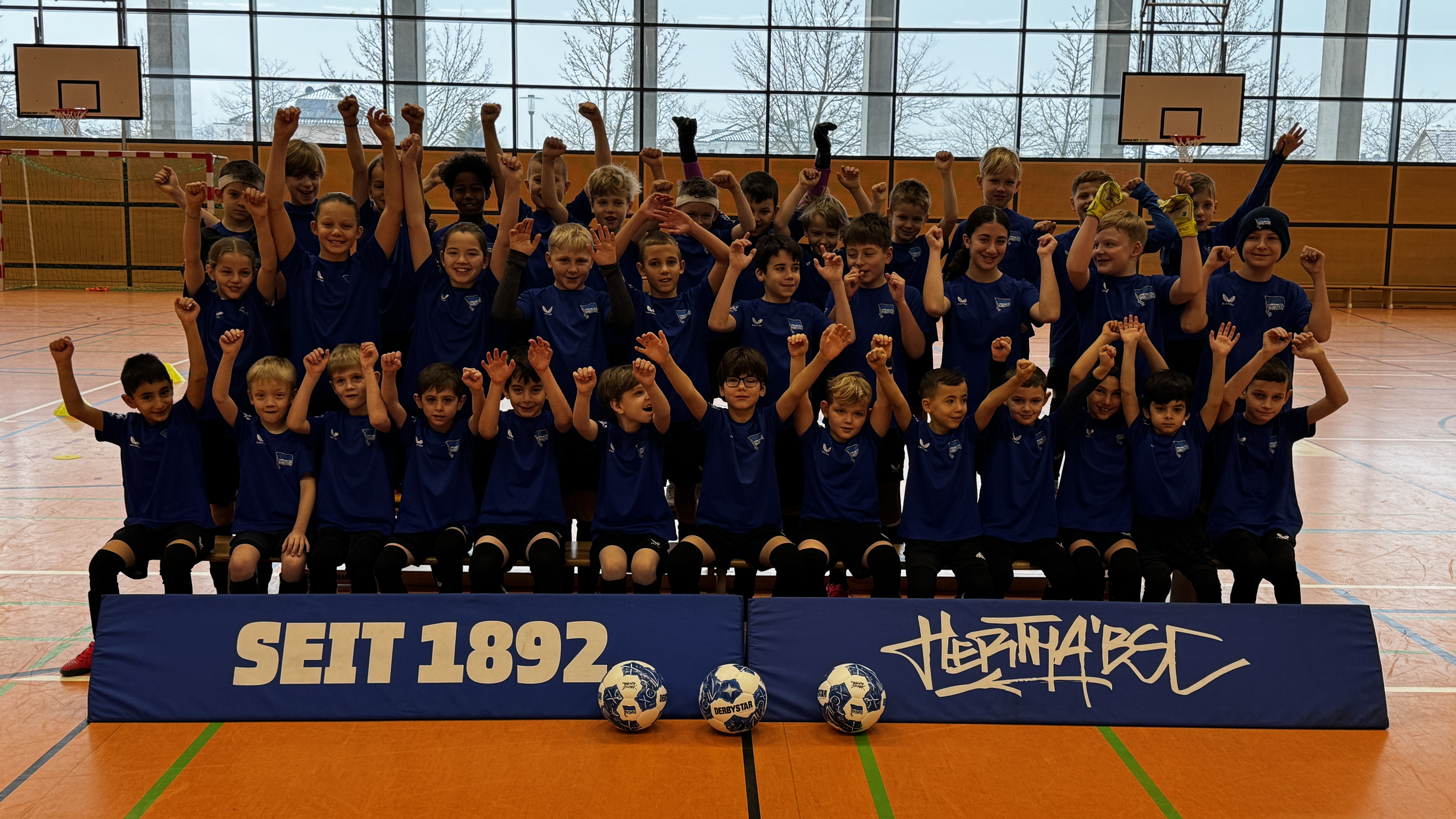 Teilnehmende der Ballschule in einer Halle.