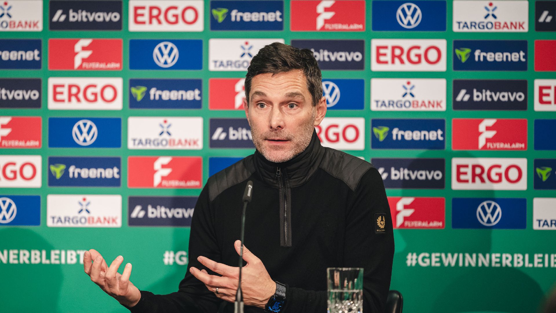Stefan Leitl sitzt auf dem Podium.