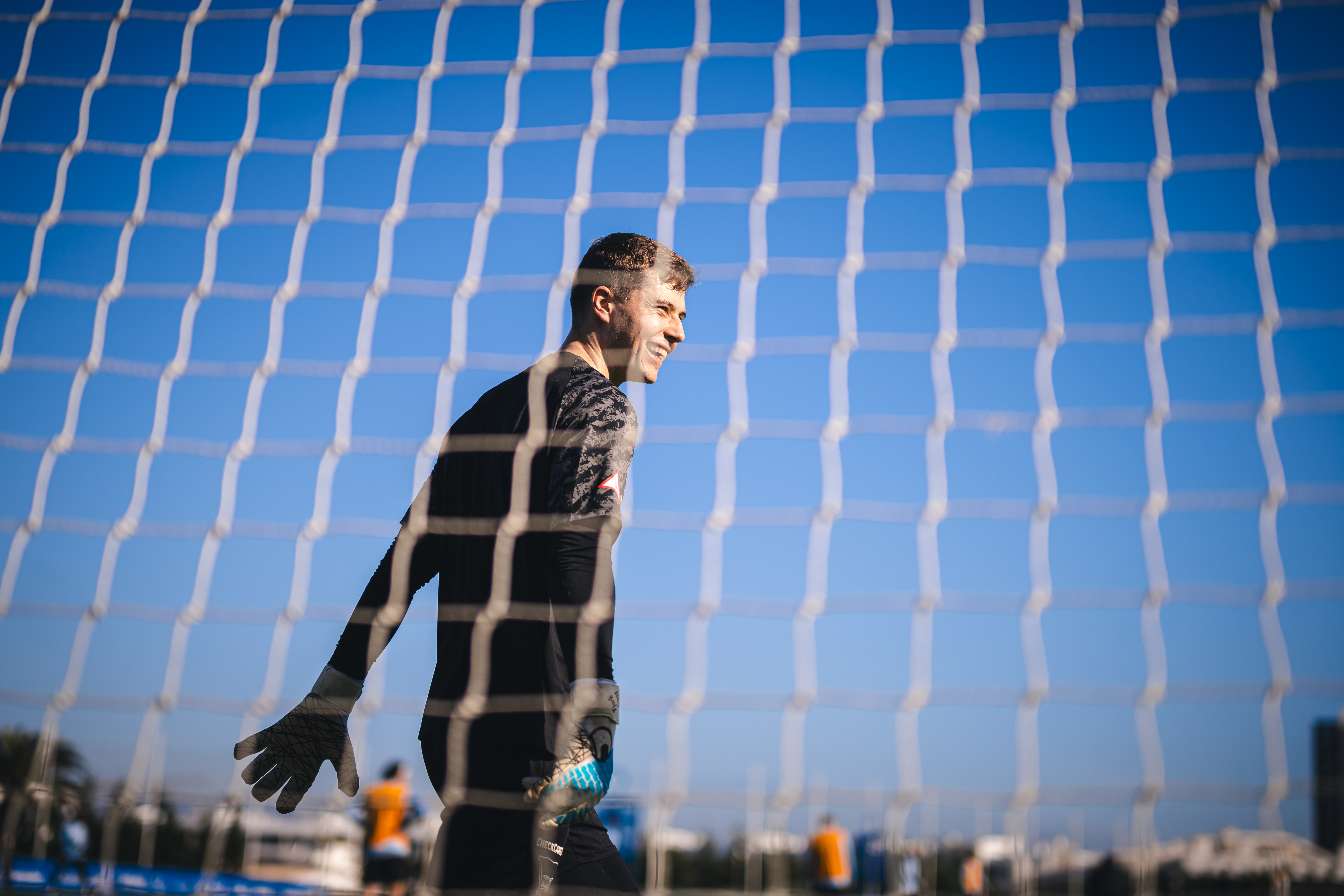 Tjark Ernst lacht durch ein Tornetz.
