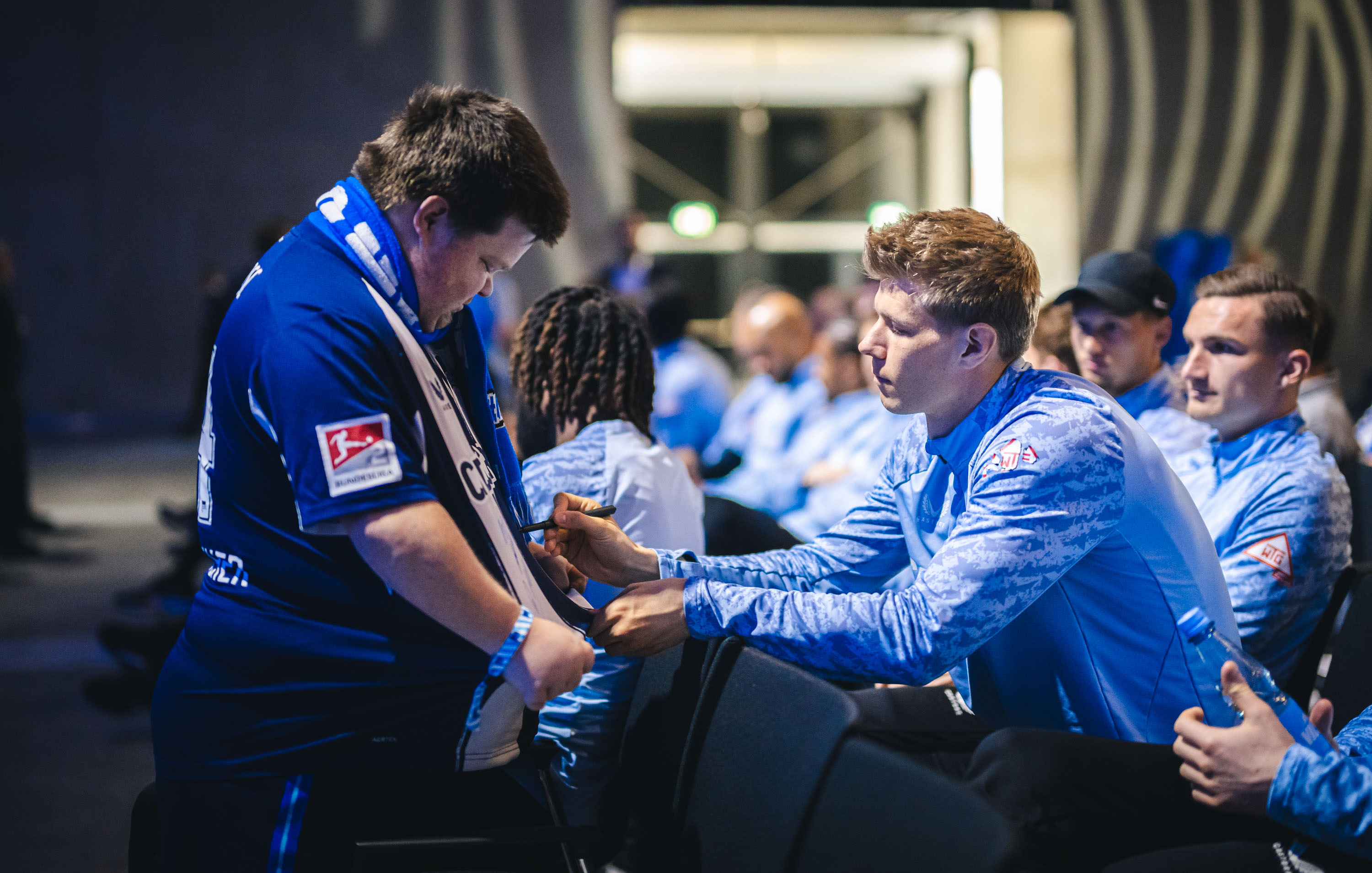 Ein Fan lässt sein Trikot unterschreiben.