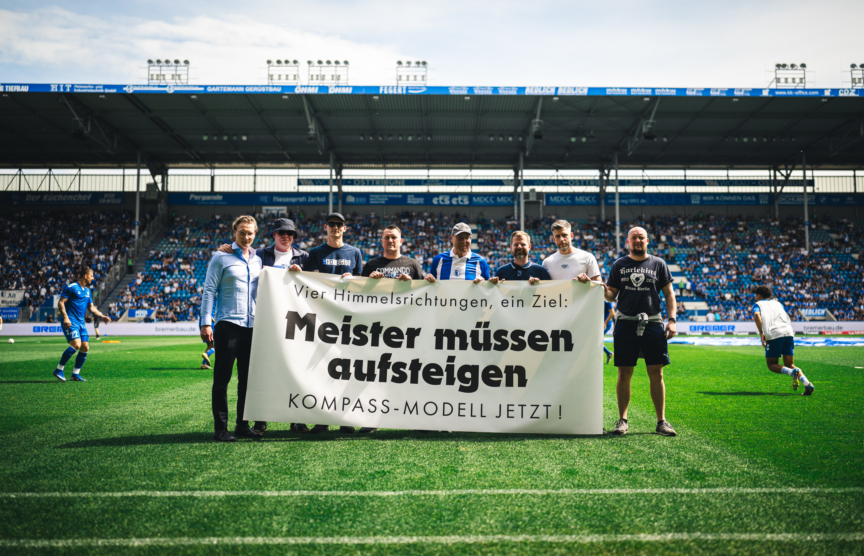 Verantwortliche vor einem Spruchbanner zur Aufstiegsreform.