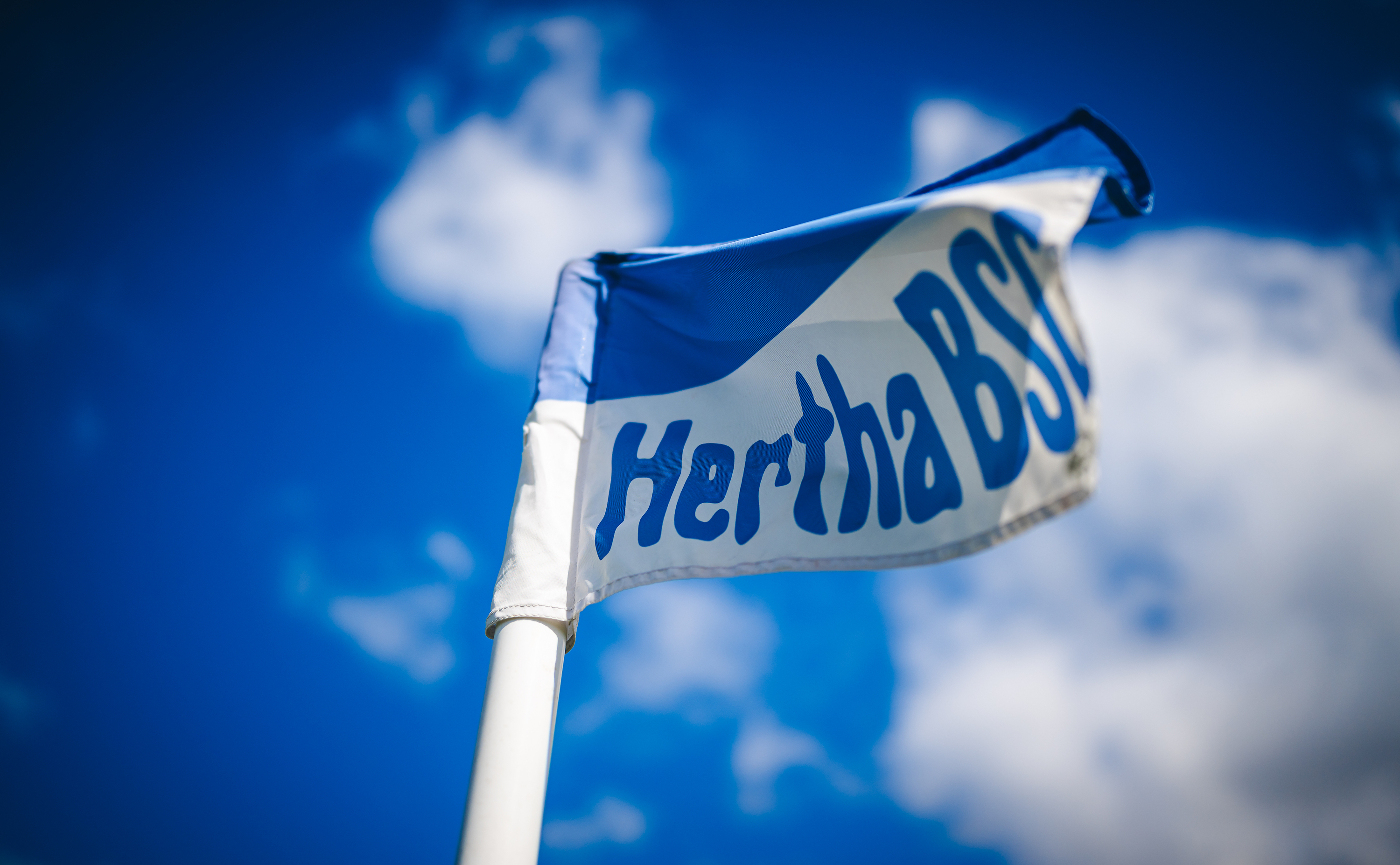 Eine blau-weiße Eckfahne unter blauem Himmel.