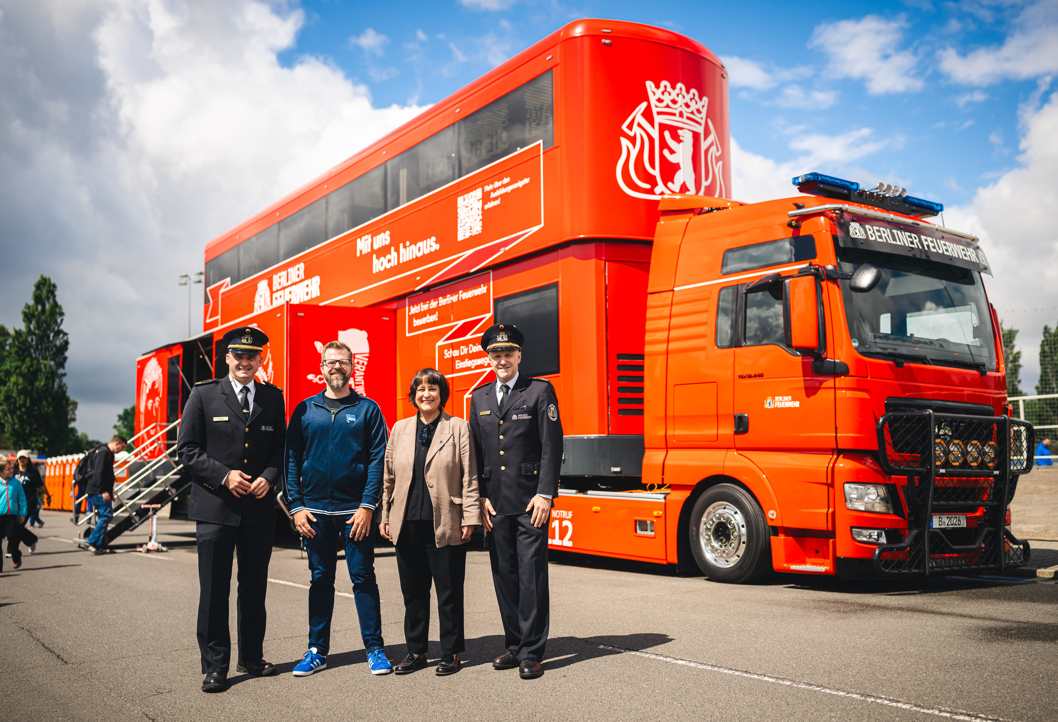 Vinzenz Kasch, Fabian Drescher, Franziska Becker und Arvid Graeger stehen vor einem Feuerwehrauto.