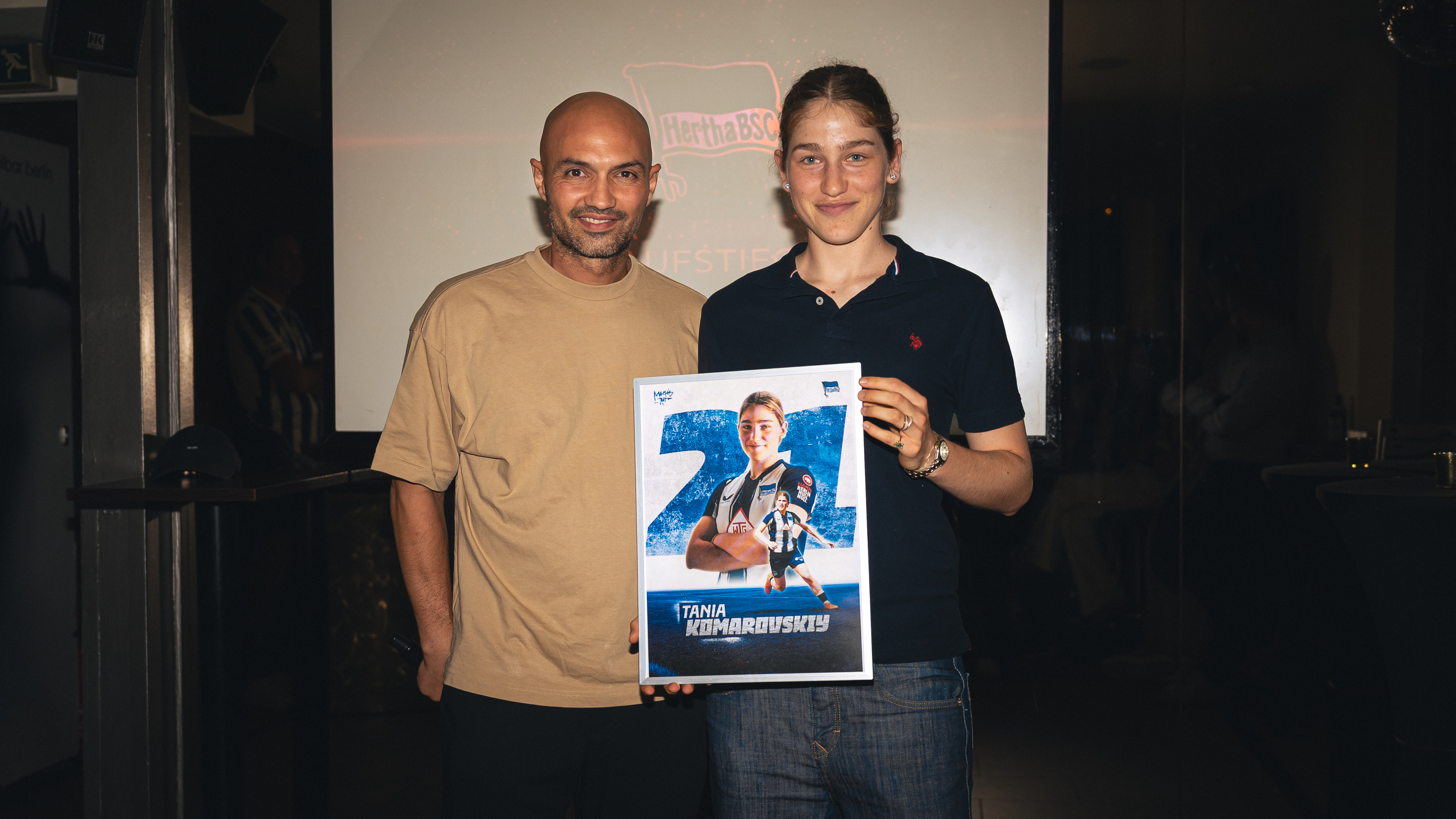 Sofian Chahed und Tania Komarovskiy halten ein Bild in die Höhe.
