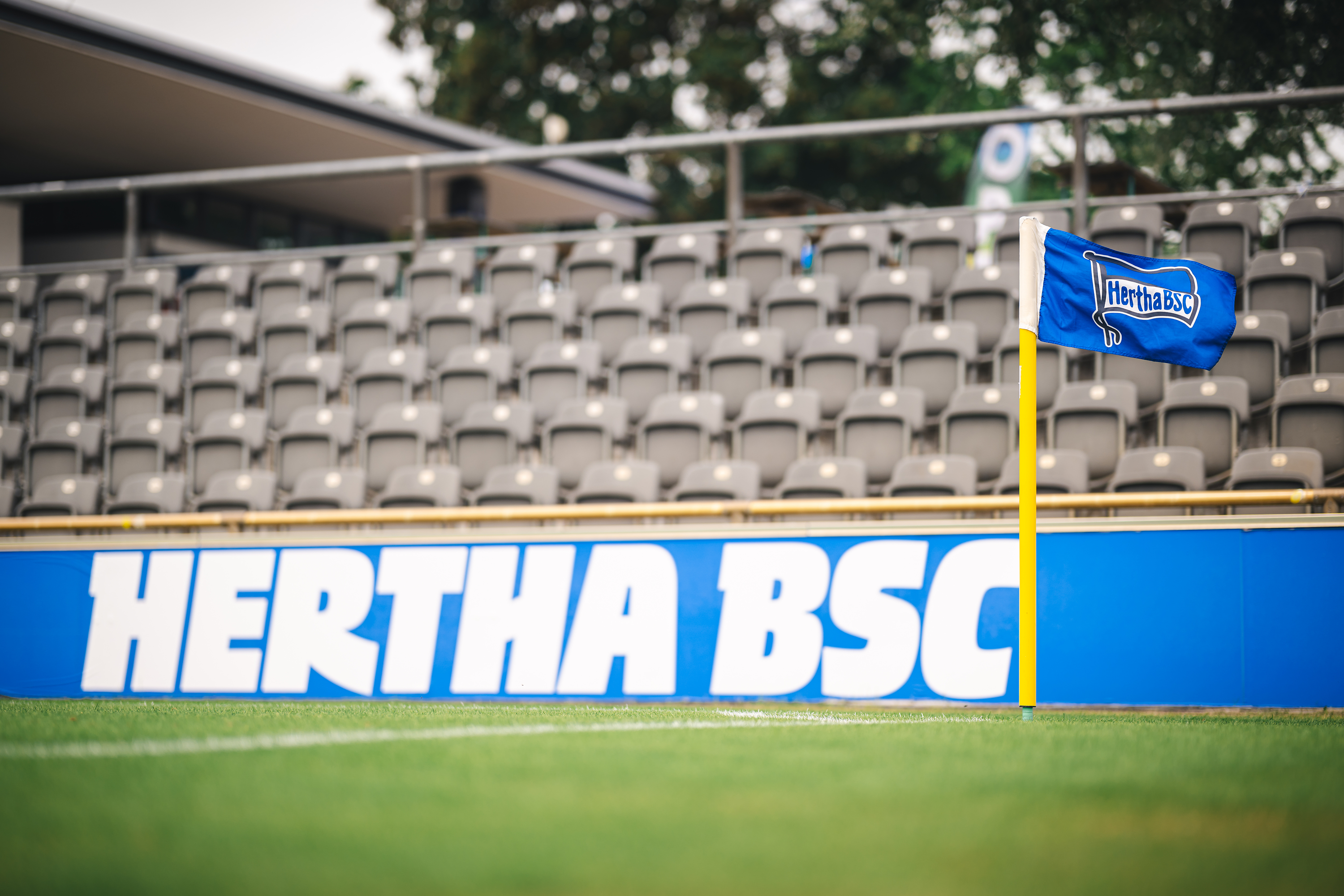 Eine Eckfahne und ein Hertha-Schriftzug auf der Werbebande im Stadion auf dem Wurfplatz/Amateurstadion.