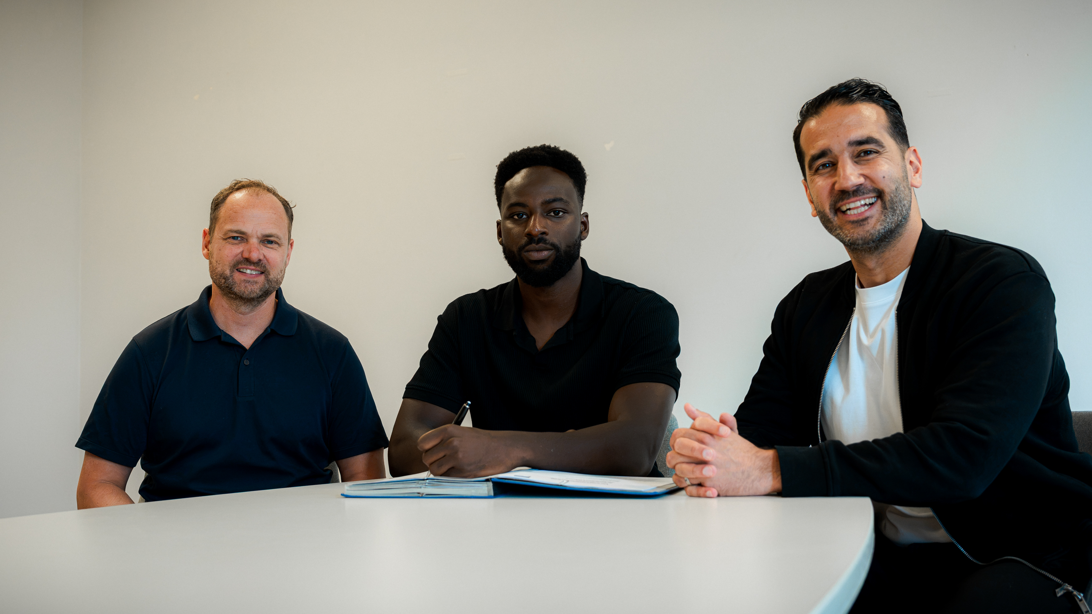 Björn Müller, Mustafa Kourouma und Sasan Gouhari bei der Vertragsunterschrift.