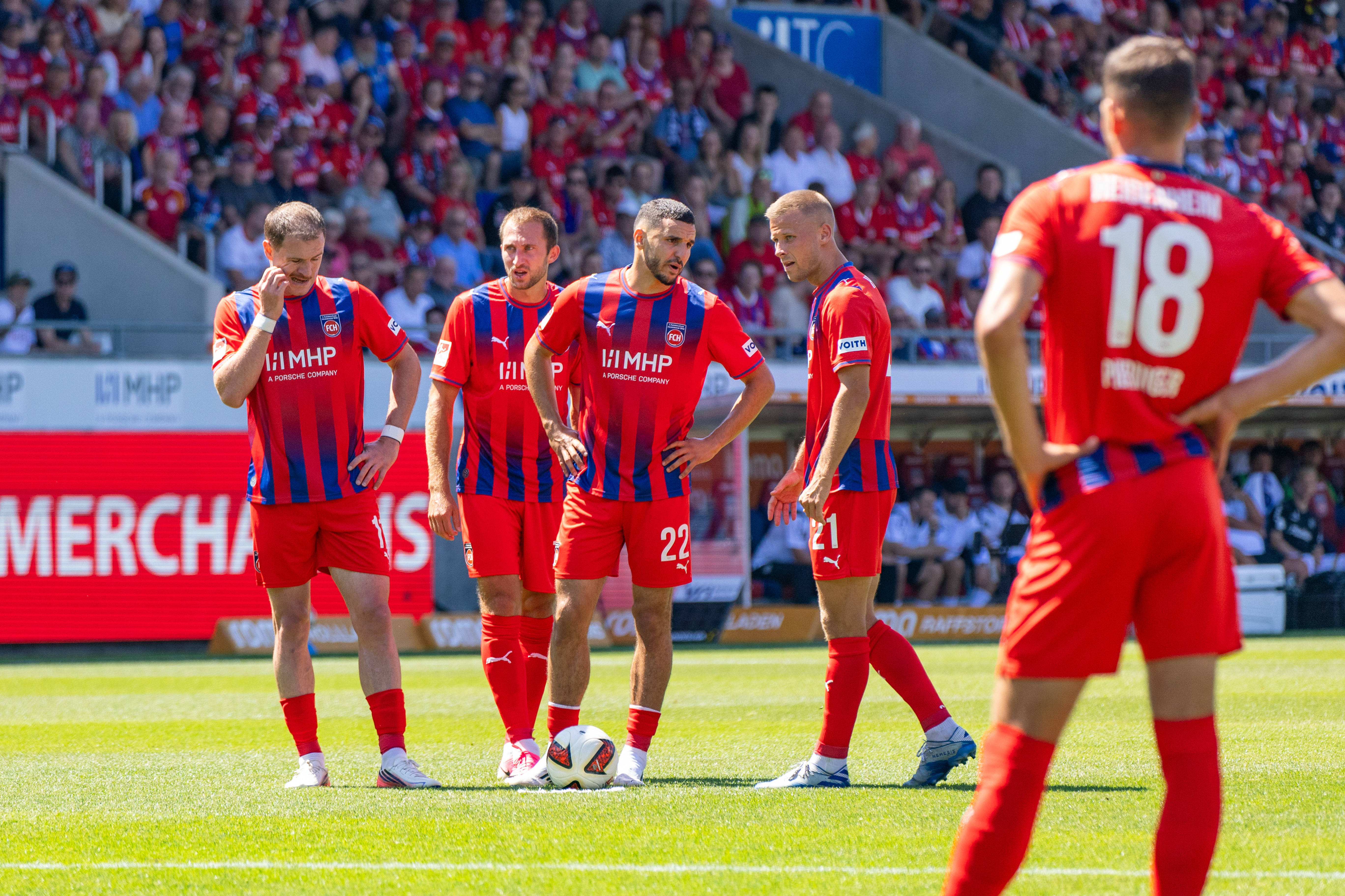 Heidenheimer Spieler stehen vor einem Freistoß um den Ball herum.