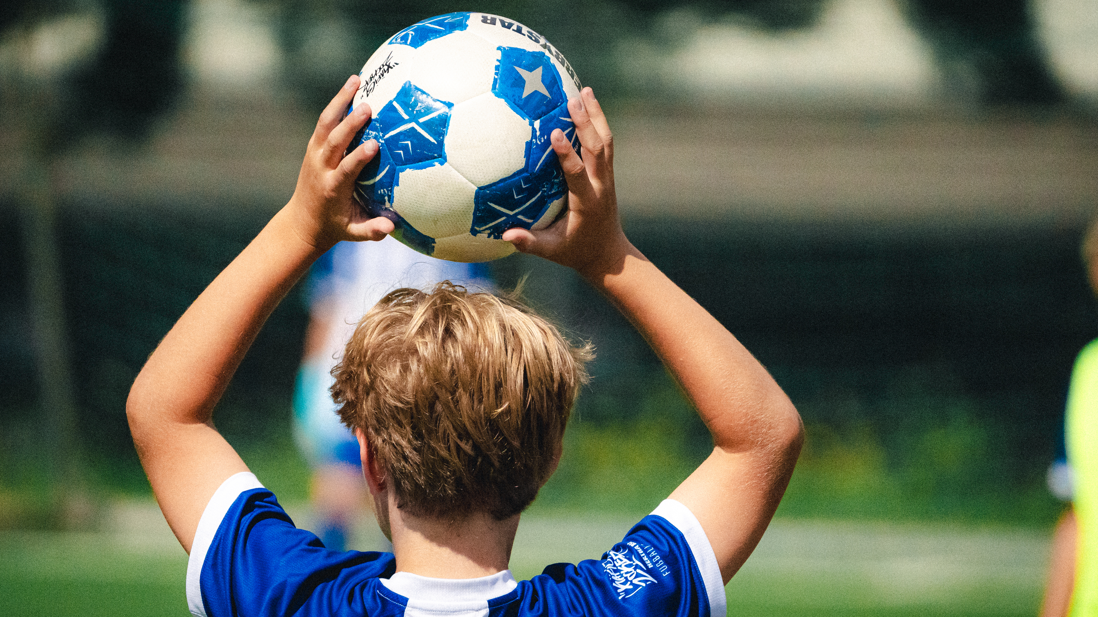 Ein Kind wirft einen Ball ein.