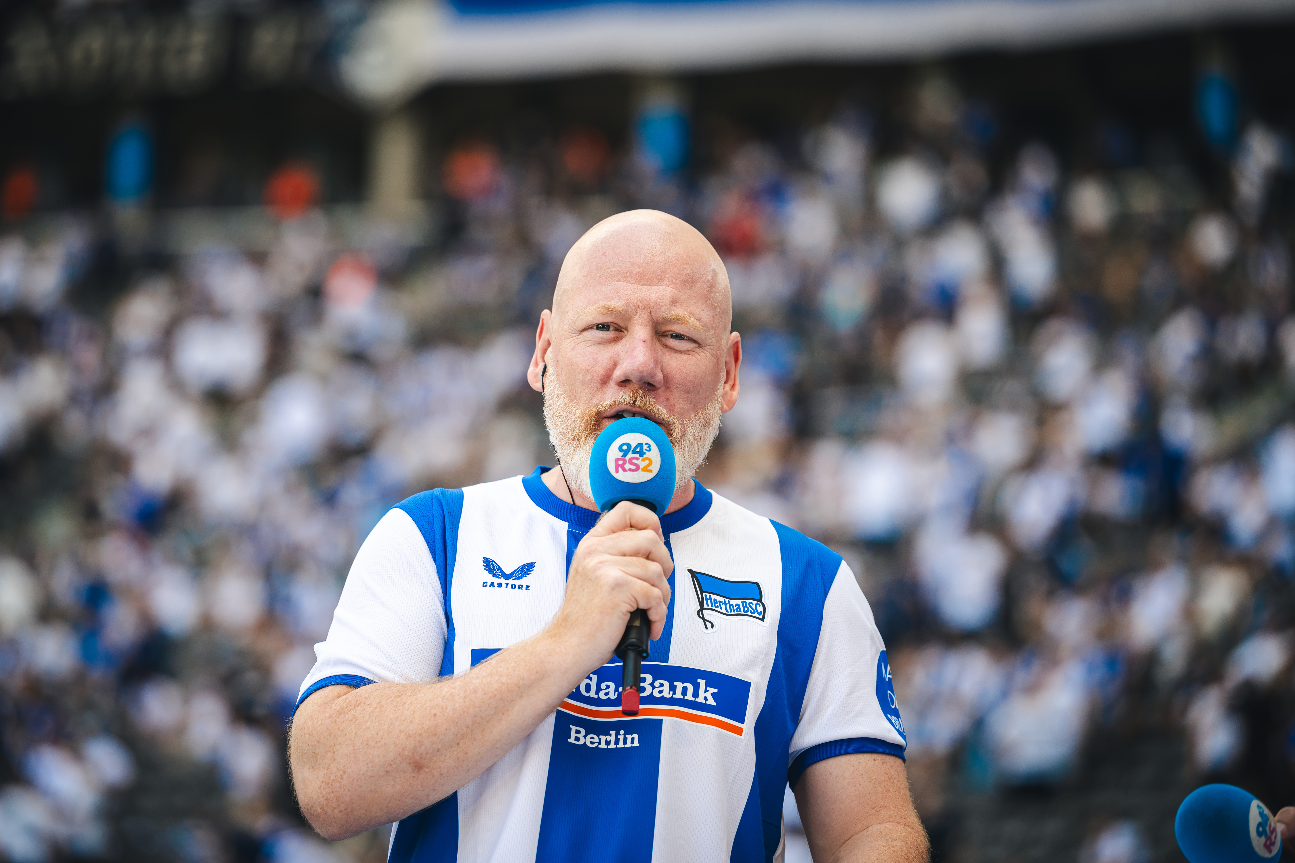Udo Knierim am Mikrofon auf der Tartanbahn im Olympiastadion.