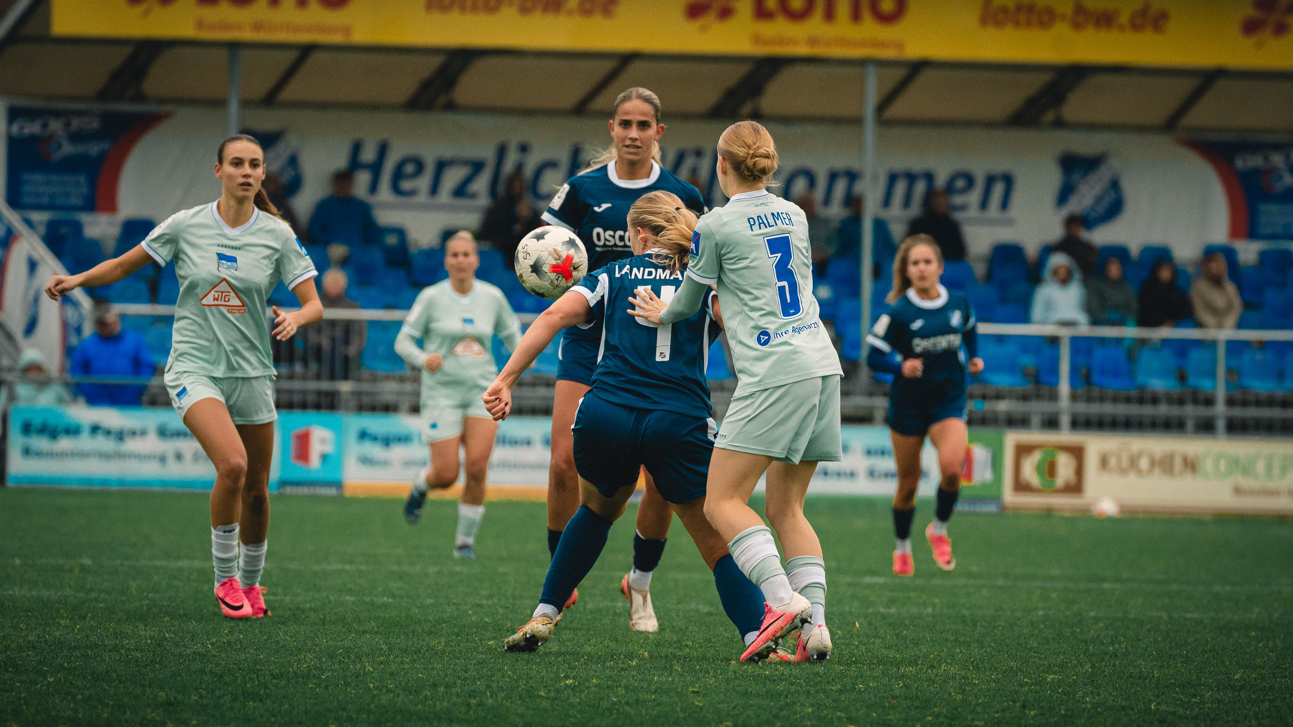 Nelly Palmer im Zweikampf mit zwei Gegenspielerinnen von Sand.